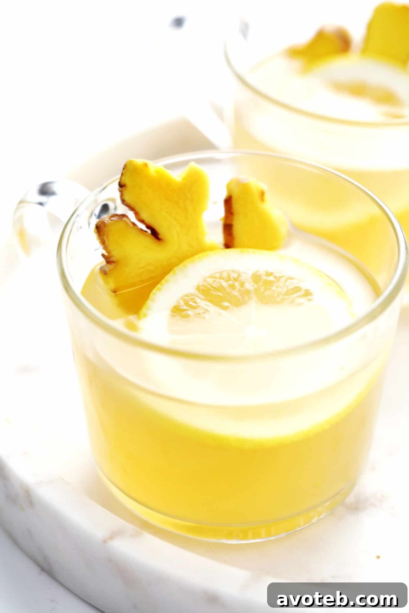 Hot Toddy with fresh ginger slices and a lemon twist as garnishes.
