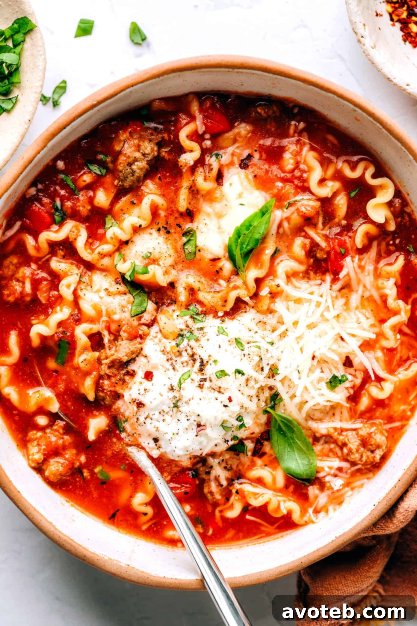 This easy lasagna soup recipe is made with Italian sausage (traditional or plant-based), a garlicky tomato herb broth, your choice of pasta, and three types of cheese (hello, mozzarella, ricotta AND Parmesan). Easy to make vegetarian, vegan and/or gluten-free if you'd like. And always such a cozy Italian 30-minute dinner recipe! | gimmesomeoven.com Hearty Lasagna Soup with Italian Sausage and Three Cheeses