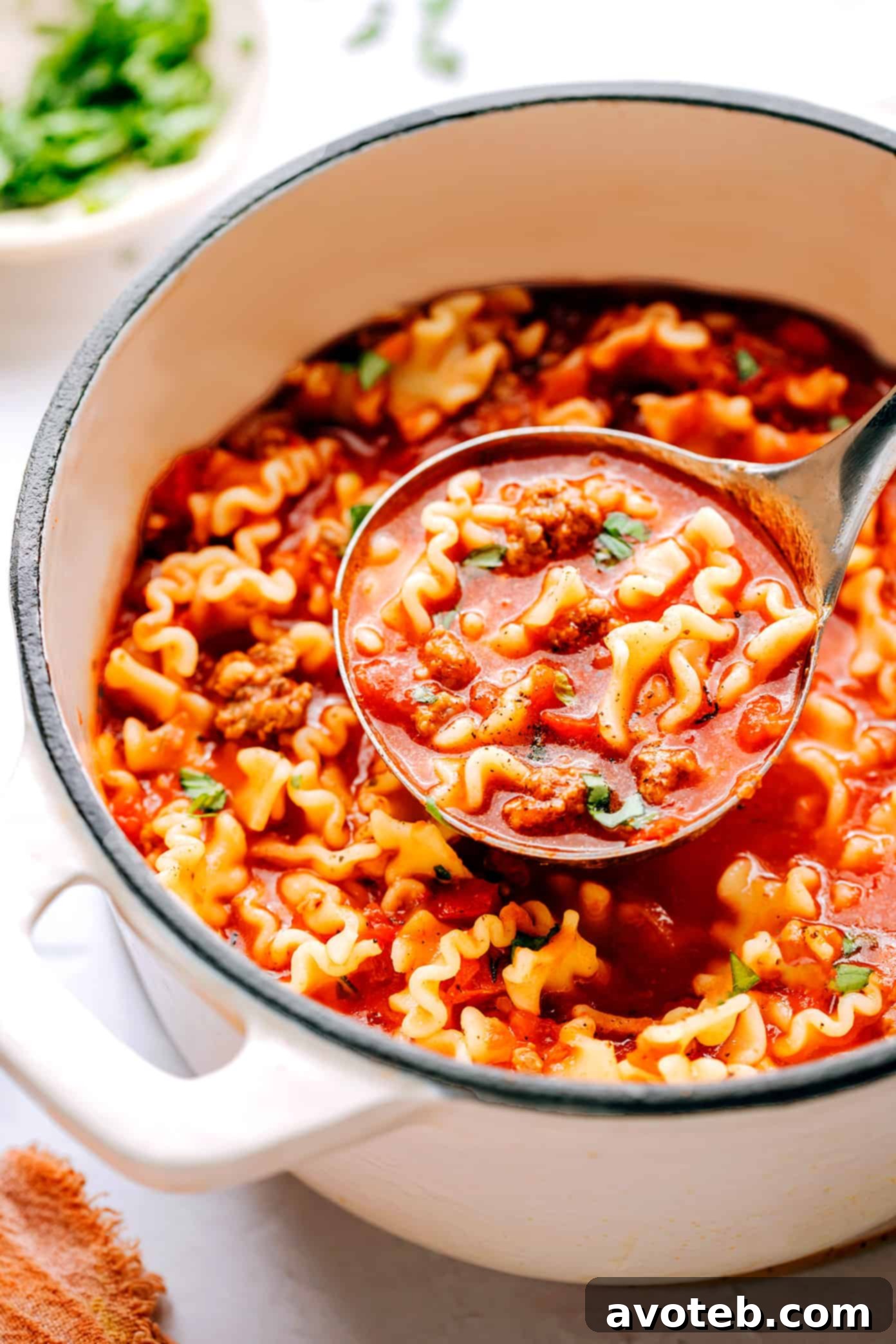 This easy lasagna soup recipe is made with Italian sausage (traditional or plant-based), a garlicky tomato herb broth, your choice of pasta, and three types of cheese (hello, mozzarella, ricotta AND Parmesan). Easy to make vegetarian, vegan and/or gluten-free if you'd like. And always such a cozy Italian 30-minute dinner recipe! | gimmesomeoven.com A pot of hearty lasagna soup ready to serve