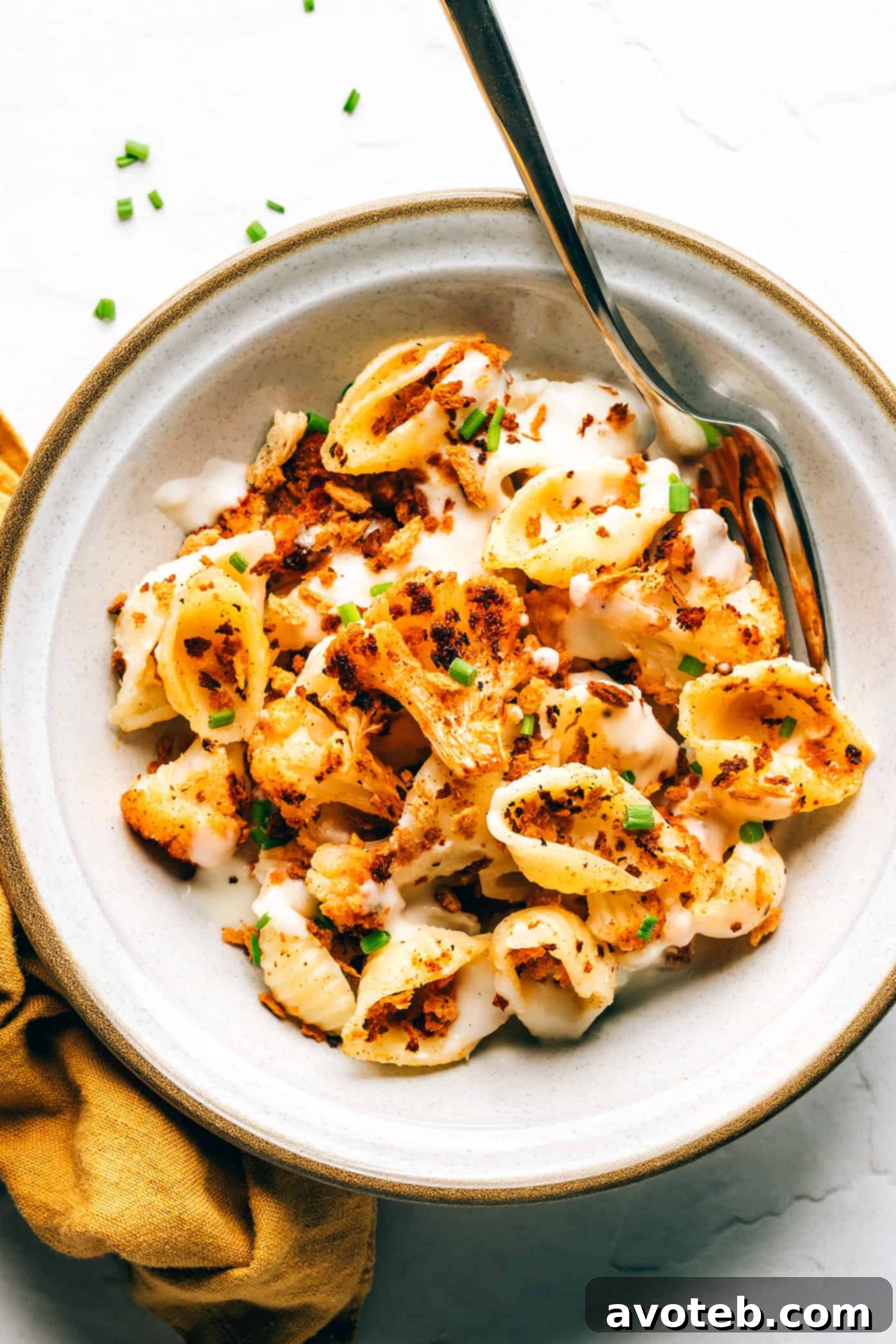 Roasted cauliflower macaroni and cheese in bowl with fork
