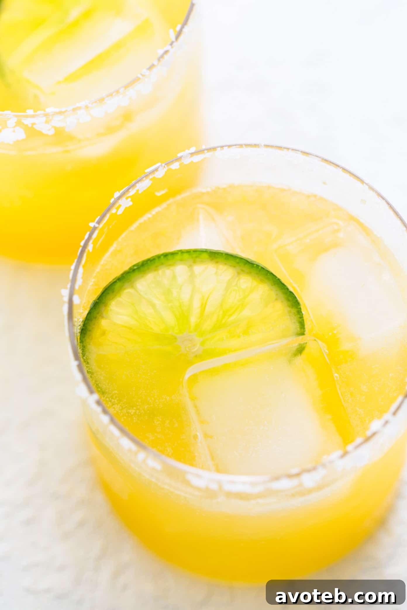This virgin margarita mocktail recipe is quick and easy to make without alcohol, yet it's still so tangy, refreshing and delicious. Perfect to serve with your favorite Mexican food...or anytime you're craving a great mocktail! Virgin Margarita Mocktail in Glasses with Lime and Salt Rims