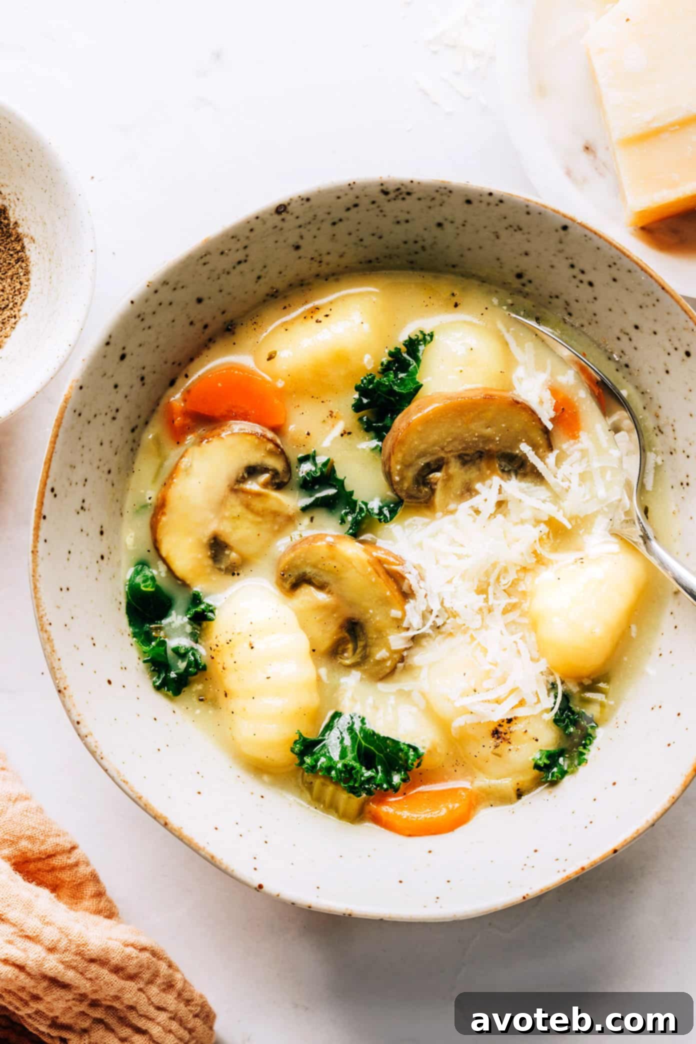 A vibrant bowl of creamy Gnocchi, Mushroom, and Kale Soup, garnished with fresh herbs and Parmesan, ready to be enjoyed. This comforting meal is quick to prepare and deeply satisfying.