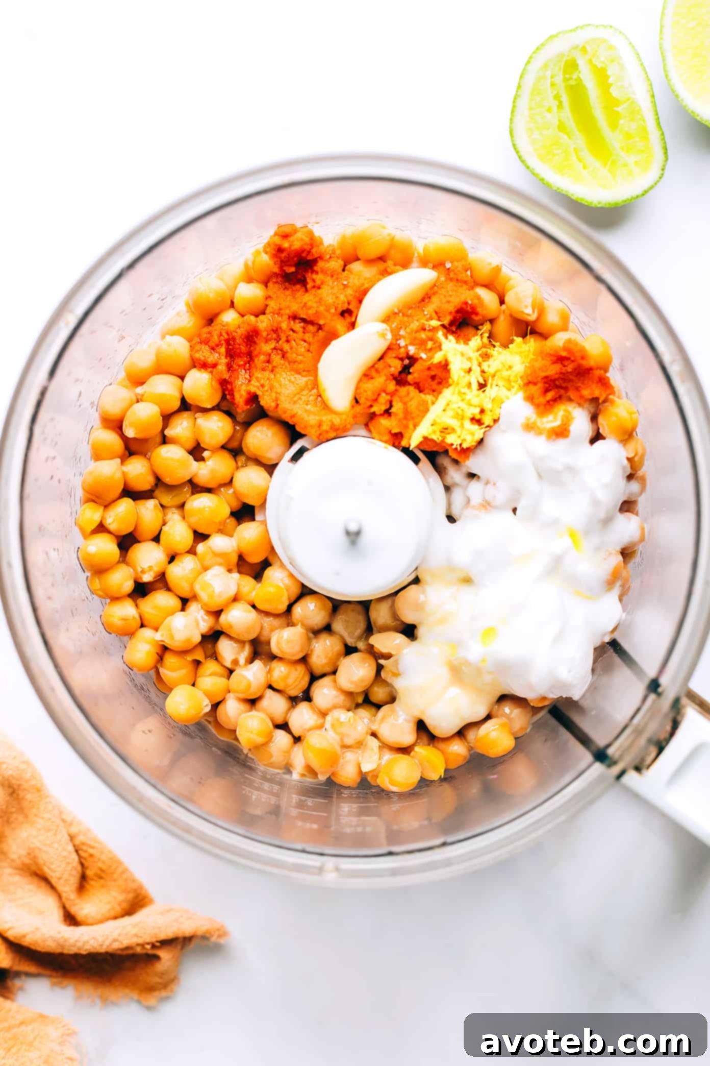Ingredients for red curry hummus being added to a food processor for blending into a smooth dip.