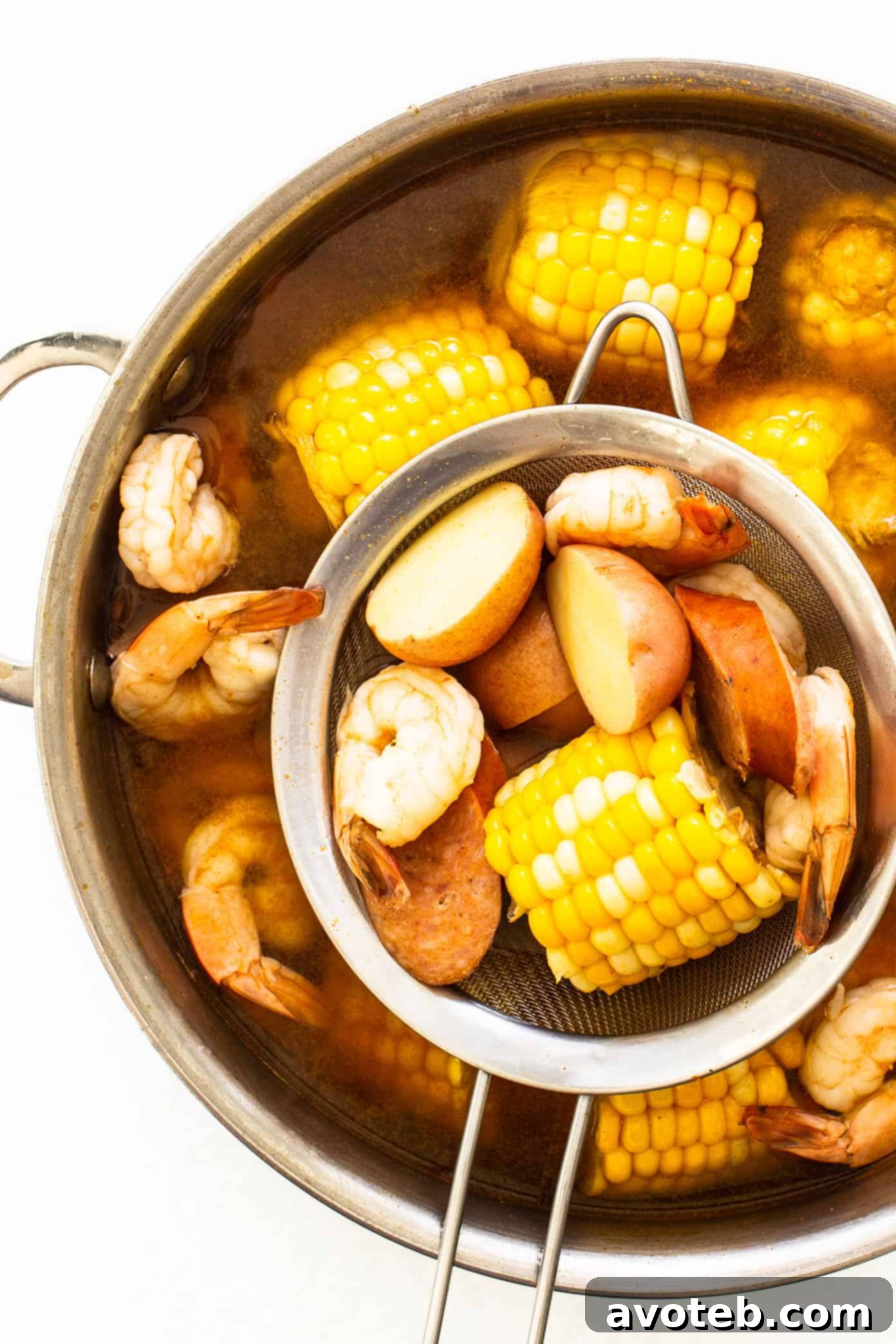 Shrimp boil simmering in a large stockpot with all ingredients