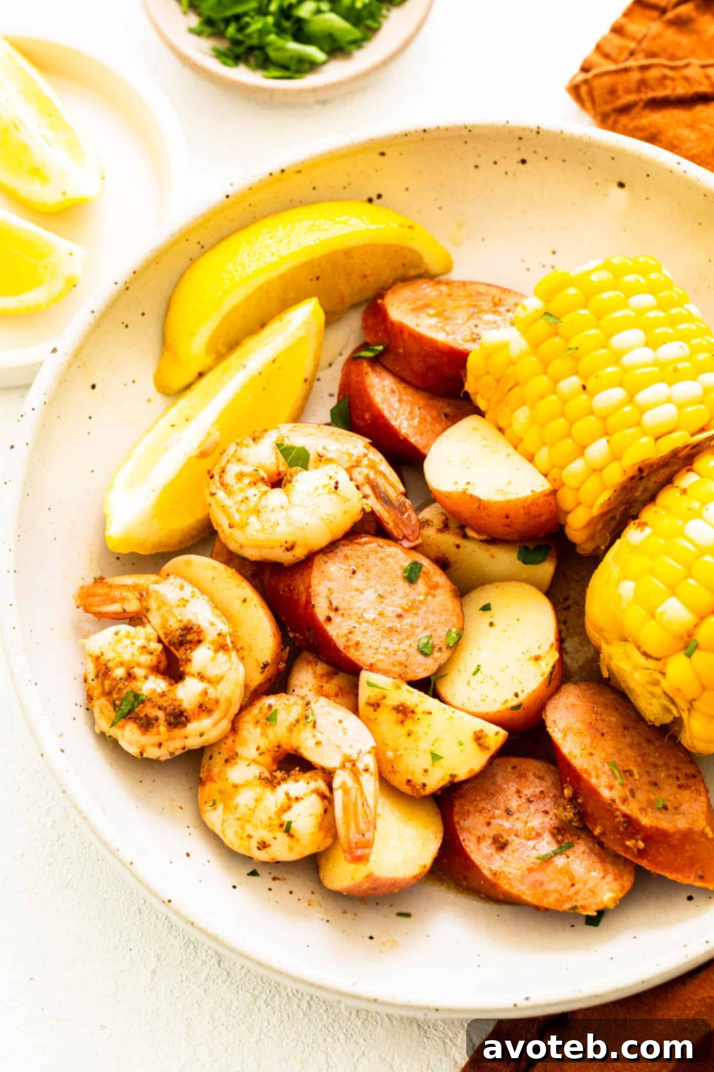 Shrimp boil beautifully plated with lemon wedges and fresh parsley