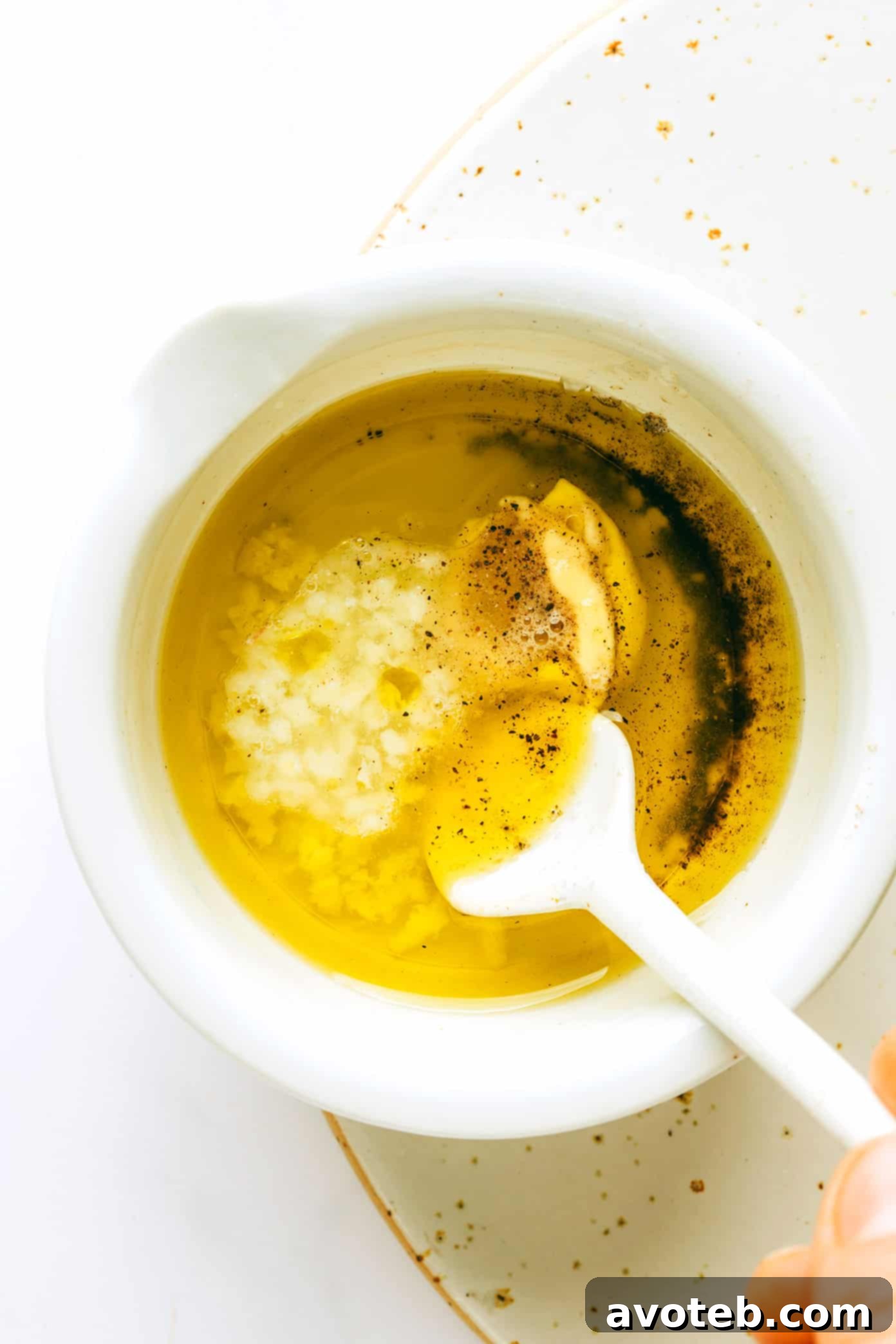 Ingredients for the lemon vinaigrette, including olive oil, fresh lemon, Dijon mustard, minced garlic, sea salt, and black pepper, neatly arranged in small bowls on a wooden surface.