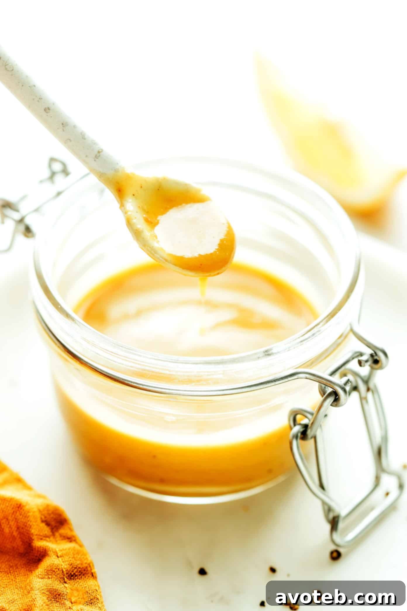 Exquisitely prepared anchovy vinaigrette, or Caesar-ish dressing, presented in a glass jar with a small spoon, ready for serving.