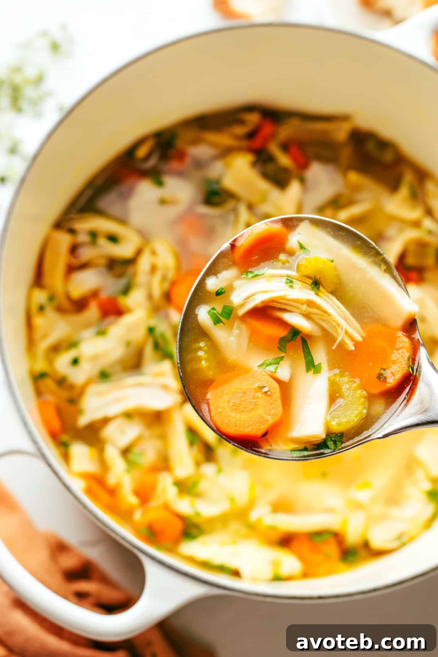 A large pot of homemade chicken noodle soup, showcasing the rich broth, tender chicken, and thick noodles.