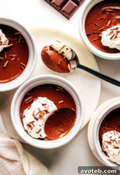 Chocolate Pots de Crème topped with whipped cream and chocolate shavings.