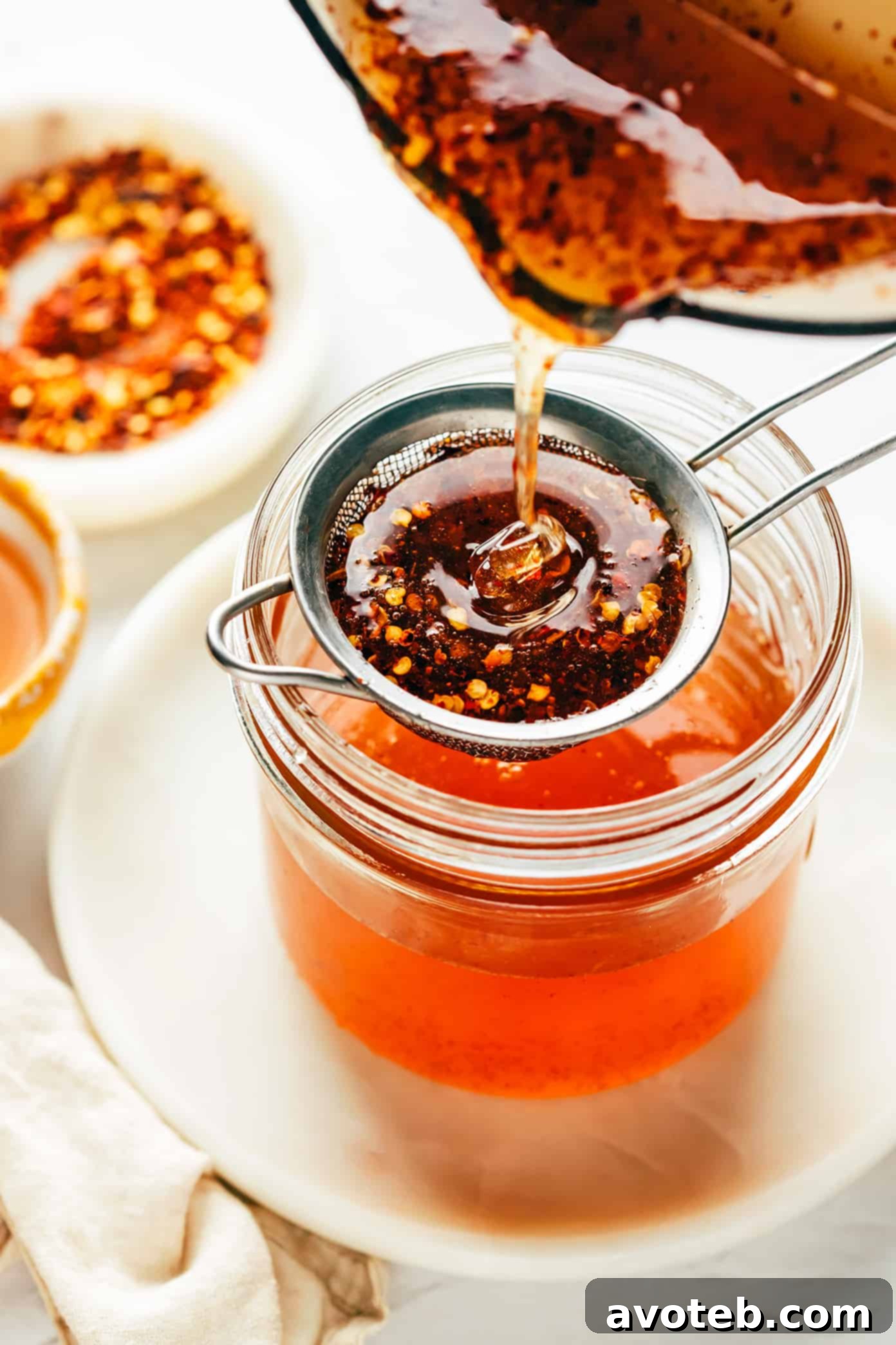 Straining hot honey into jar