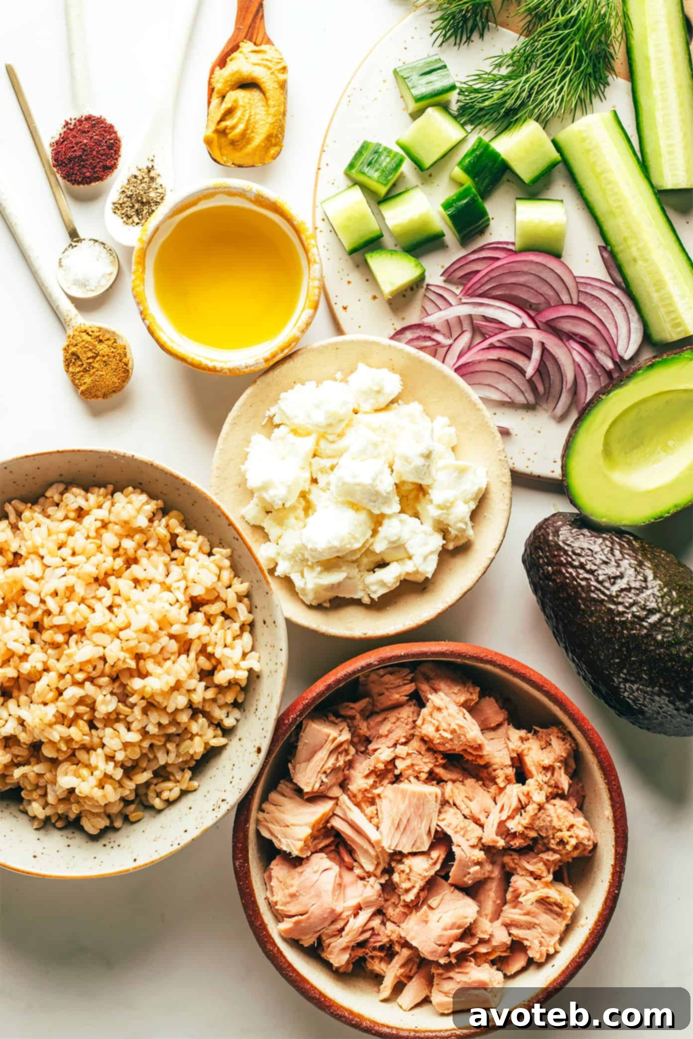 Fresh ingredients for Tuna Avocado Salad: canned tuna, avocados, cucumber, feta cheese, red onion, and fresh dill.