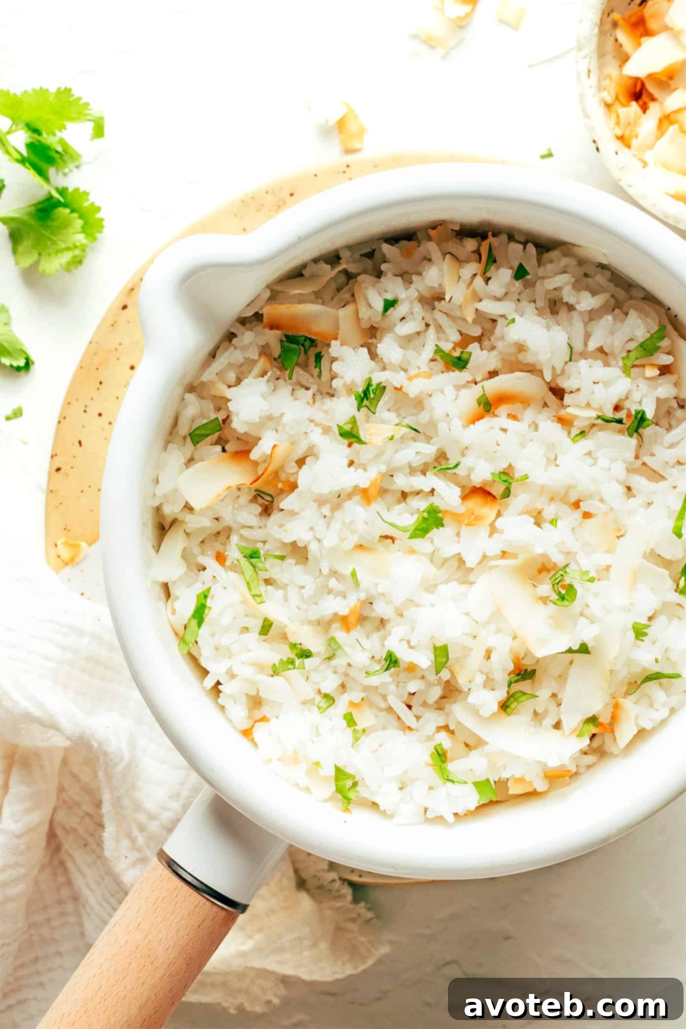 A saucepan filled with freshly cooked, fluffy coconut rice, ready to be fluffed and served.