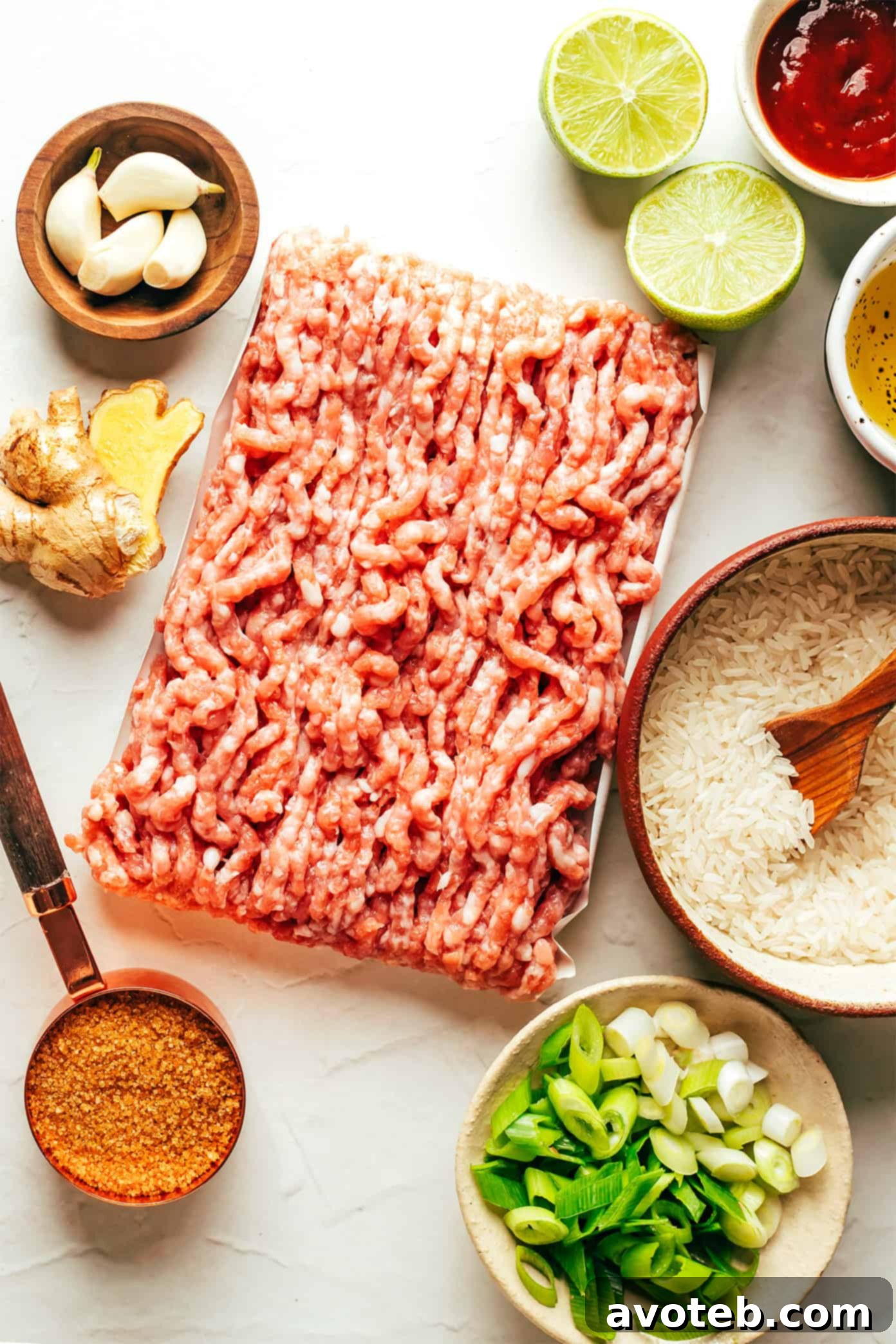 Fresh Ingredients for Flavorful Ginger Lime Pork Assortment of fresh ingredients for Ginger Lime Pork, including ground pork, scallions, ginger, garlic, lime, brown sugar, and sriracha