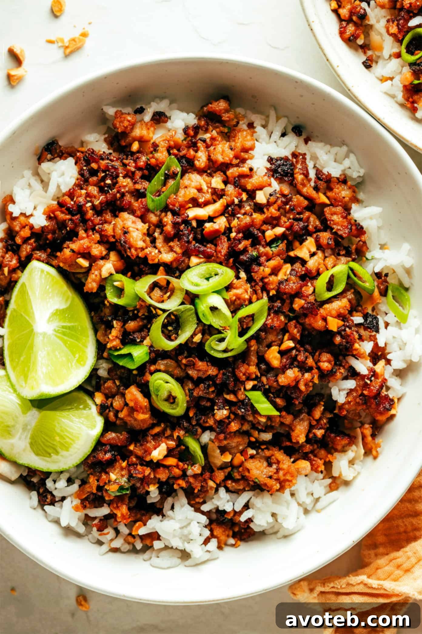 Ginger Lime Pork with Coconut Rice: A Perfect Meal Two bowls of Ginger Lime Pork with Coconut Rice, garnished with peanuts, fresh herbs, and lime wedges, ready to be served