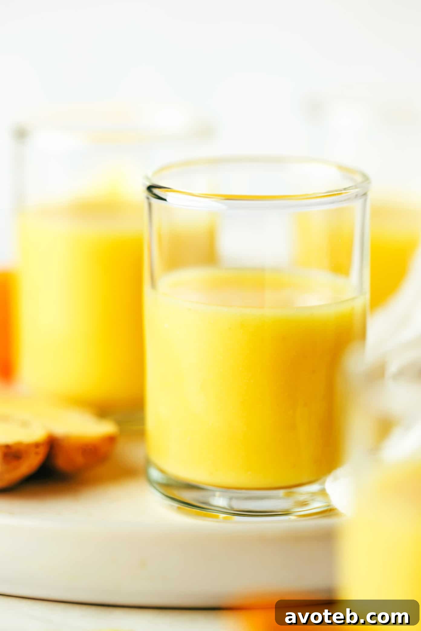 Close-up of a single ginger shot in a small glass with a slice of lime