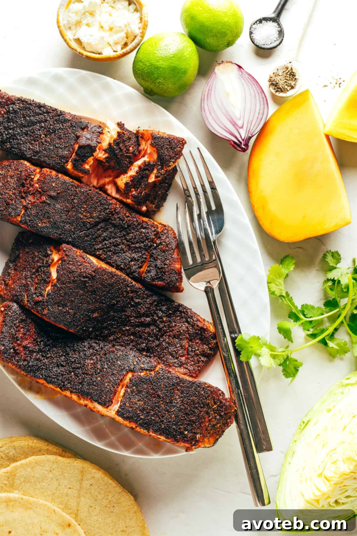 Ingredients for Blackened Salmon Tacos including salmon fillets, mango, cabbage, red onion, and cilantro.