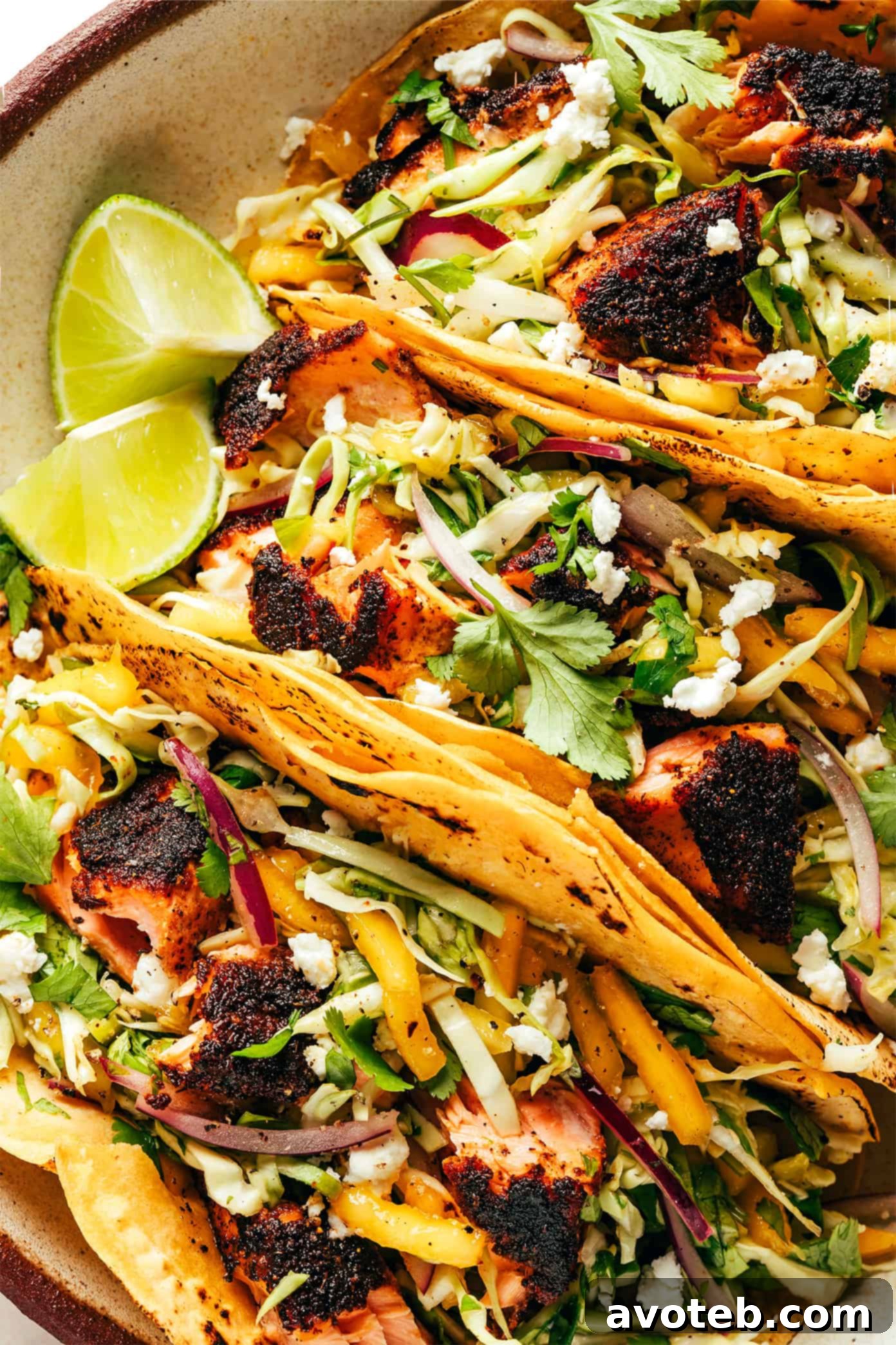 Close-up shot of a Blackened Fish Taco showcasing the flaky salmon, vibrant mango slaw, and fresh cilantro.