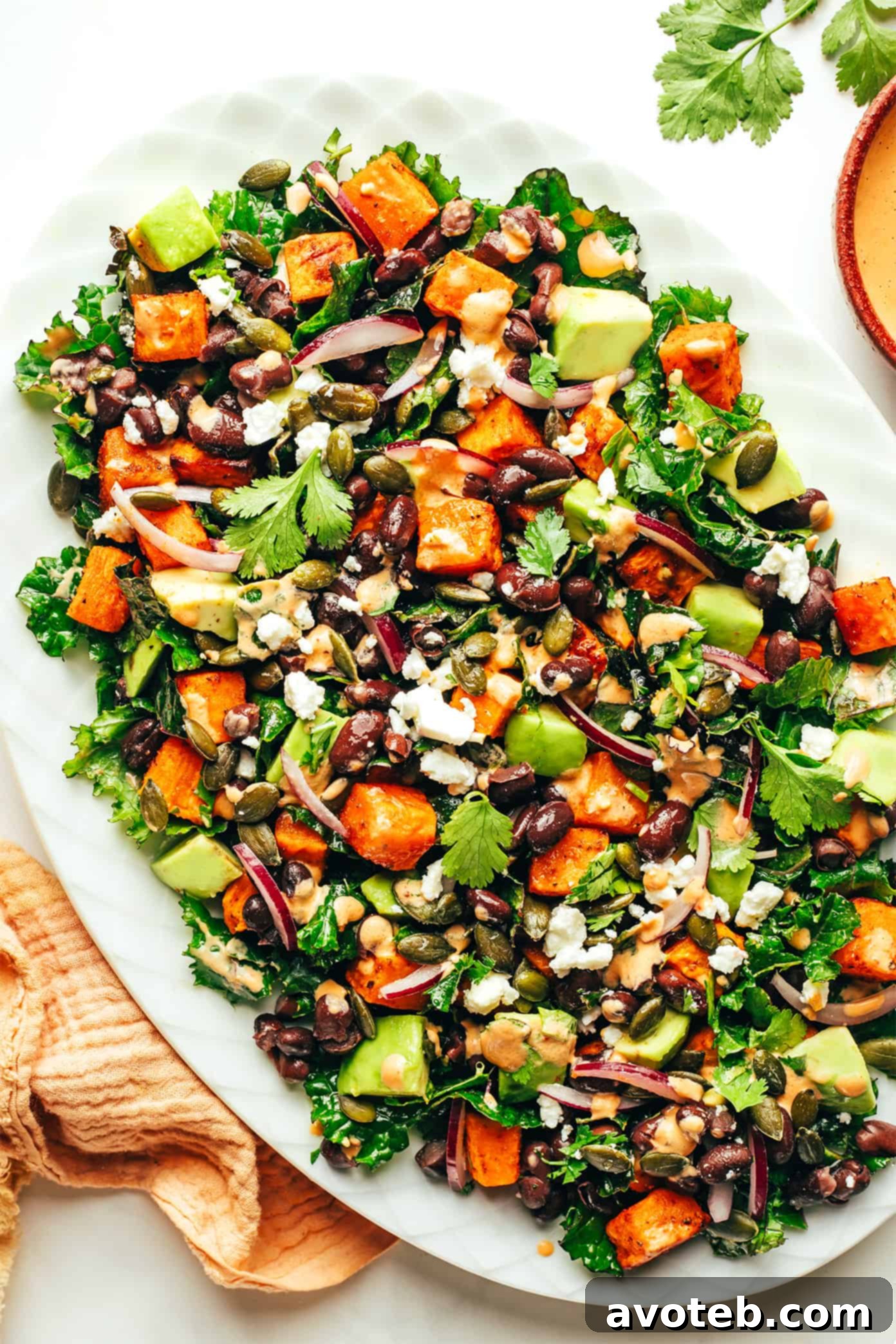 Sweet Potato Avocado Kale Salad with Chipotle Tahini Dressing served on a large platter, showcasing its colorful and hearty ingredients ready to be enjoyed.