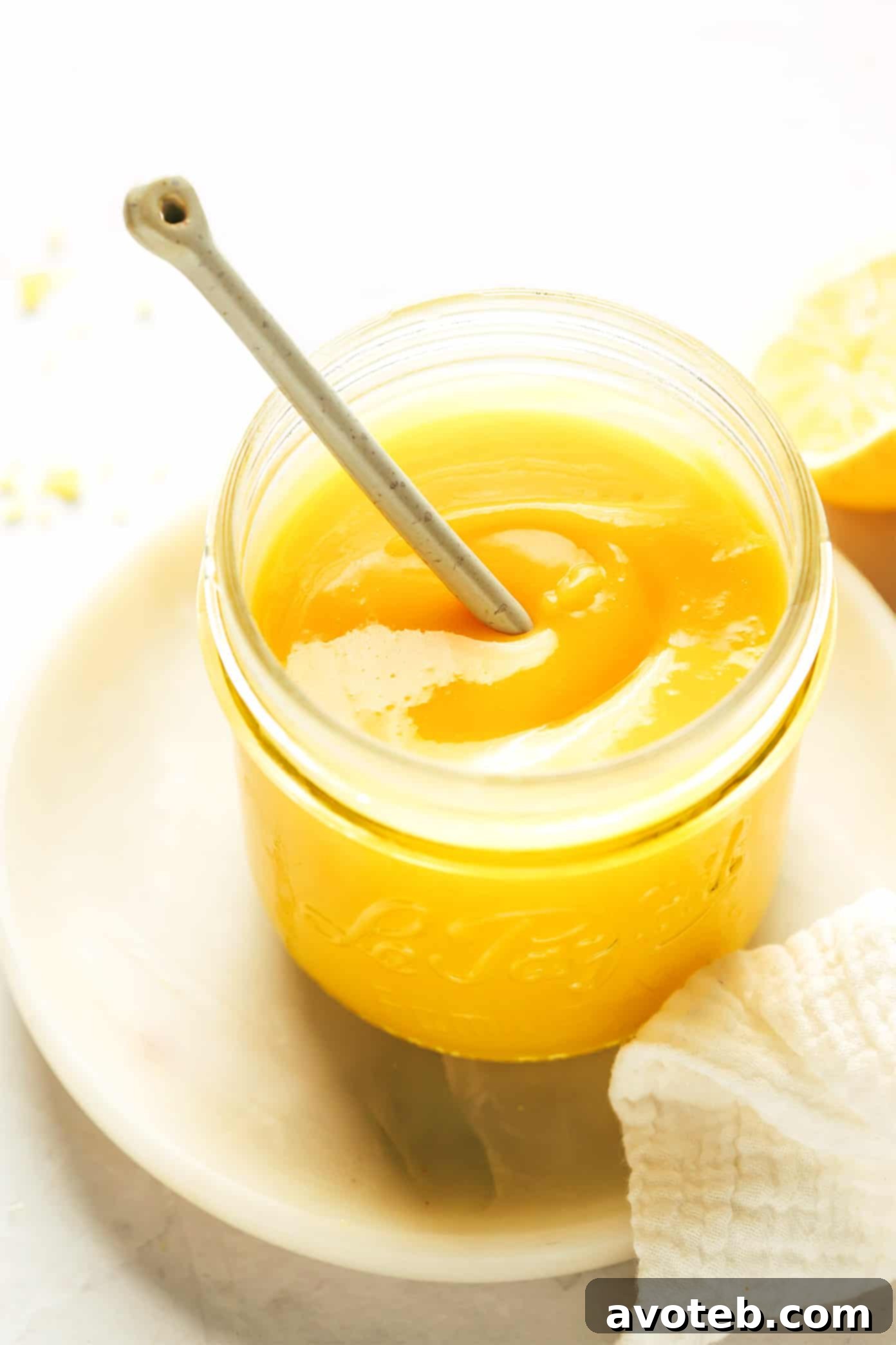 Lush jar of homemade lemon curd with a spoon, ready to be enjoyed