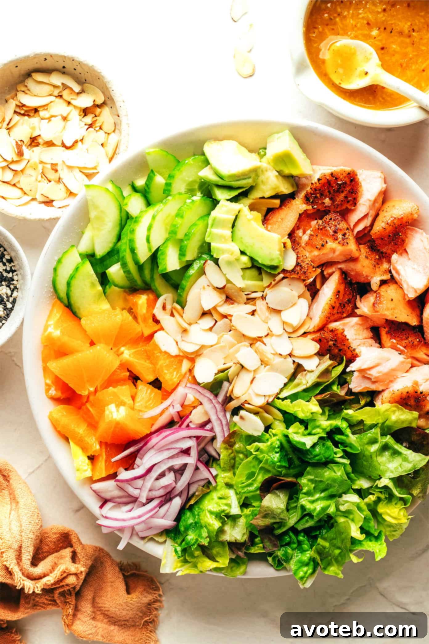 Prepped ingredients for Orange Salmon Salad arranged in a large serving bowl, ready for tossing with salmon and dressing.