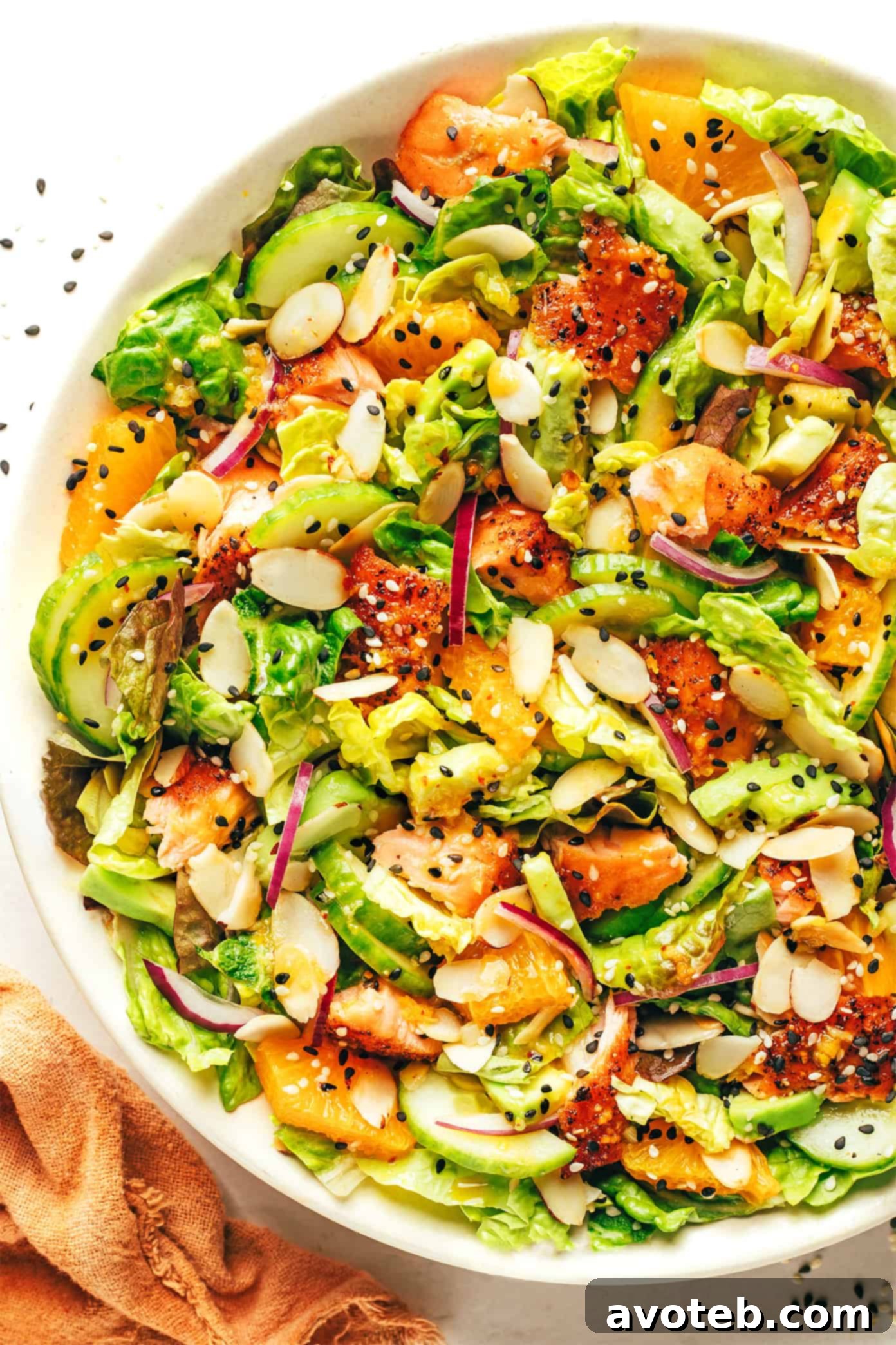 Close-up of Orange Salmon Salad in a bowl, showing a generous amount of avocado slices and toasted almonds.