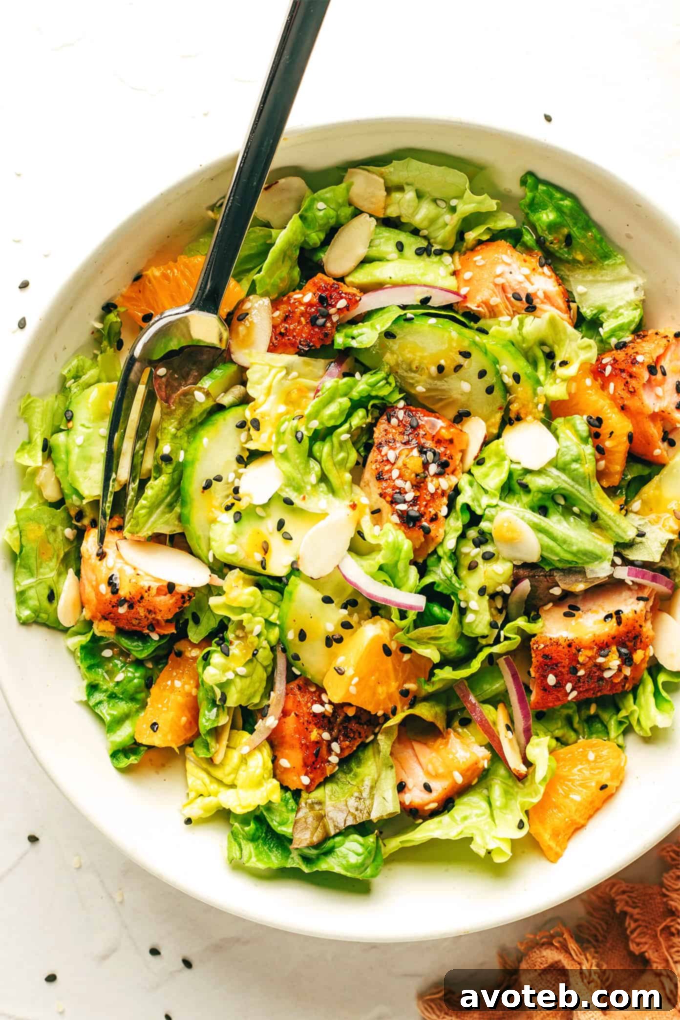 Beautifully plated Orange Salmon Salad in a serving bowl, garnished with fresh herbs and an extra drizzle of ginger hot honey vinaigrette.