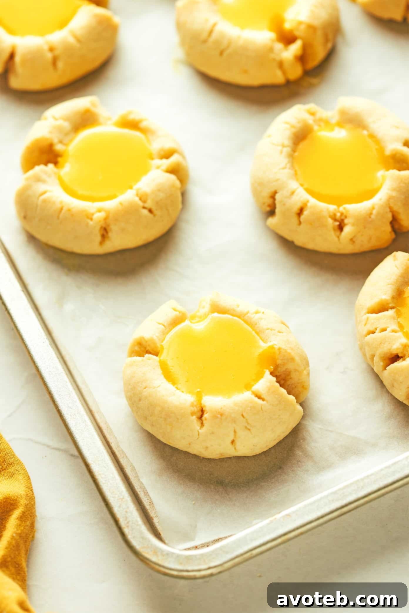 Freshly baked lemon thumbprints cooling on a baking sheet