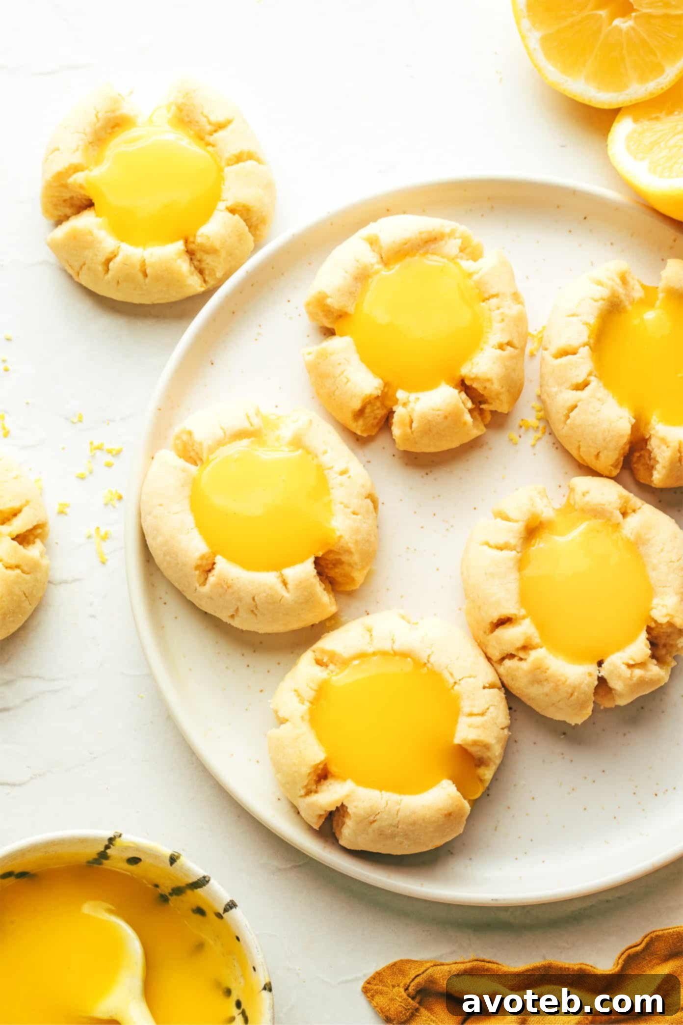 Plate of Lemon Thumbprint Cookies with extra lemon curd on the side