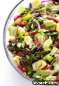 The Our Family's Favorite Salad recipe card image, featuring the finished salad with artichoke hearts, roasted red peppers, and a Parmesan vinaigrette.