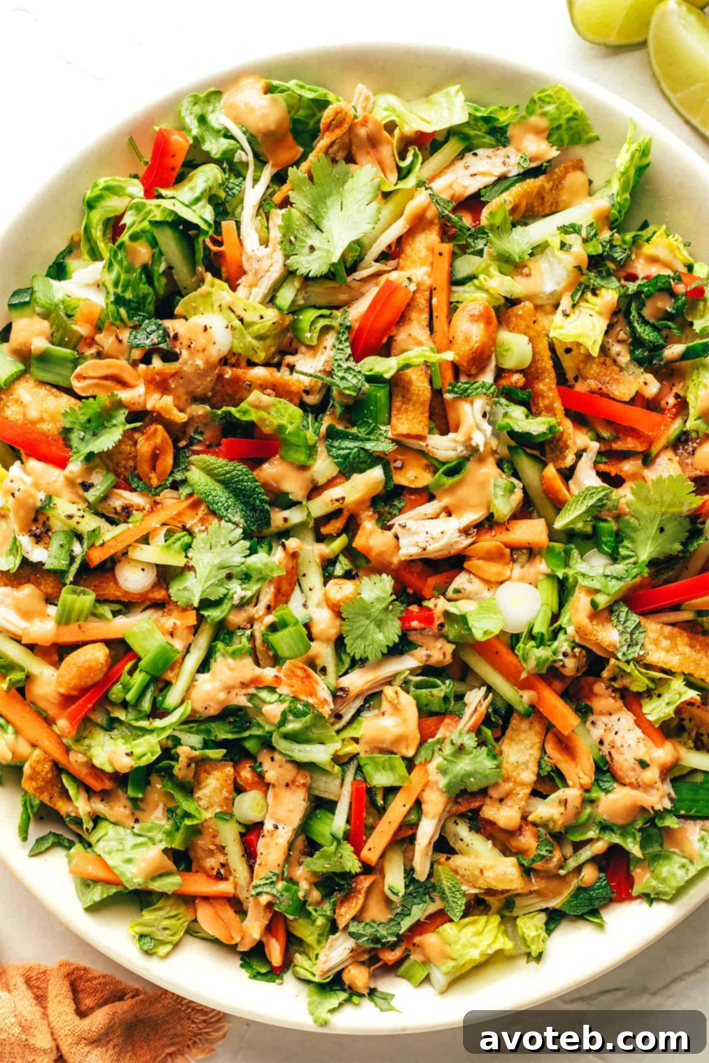 Thai Crunch Salad in a bowl drizzled with creamy peanut dressing
