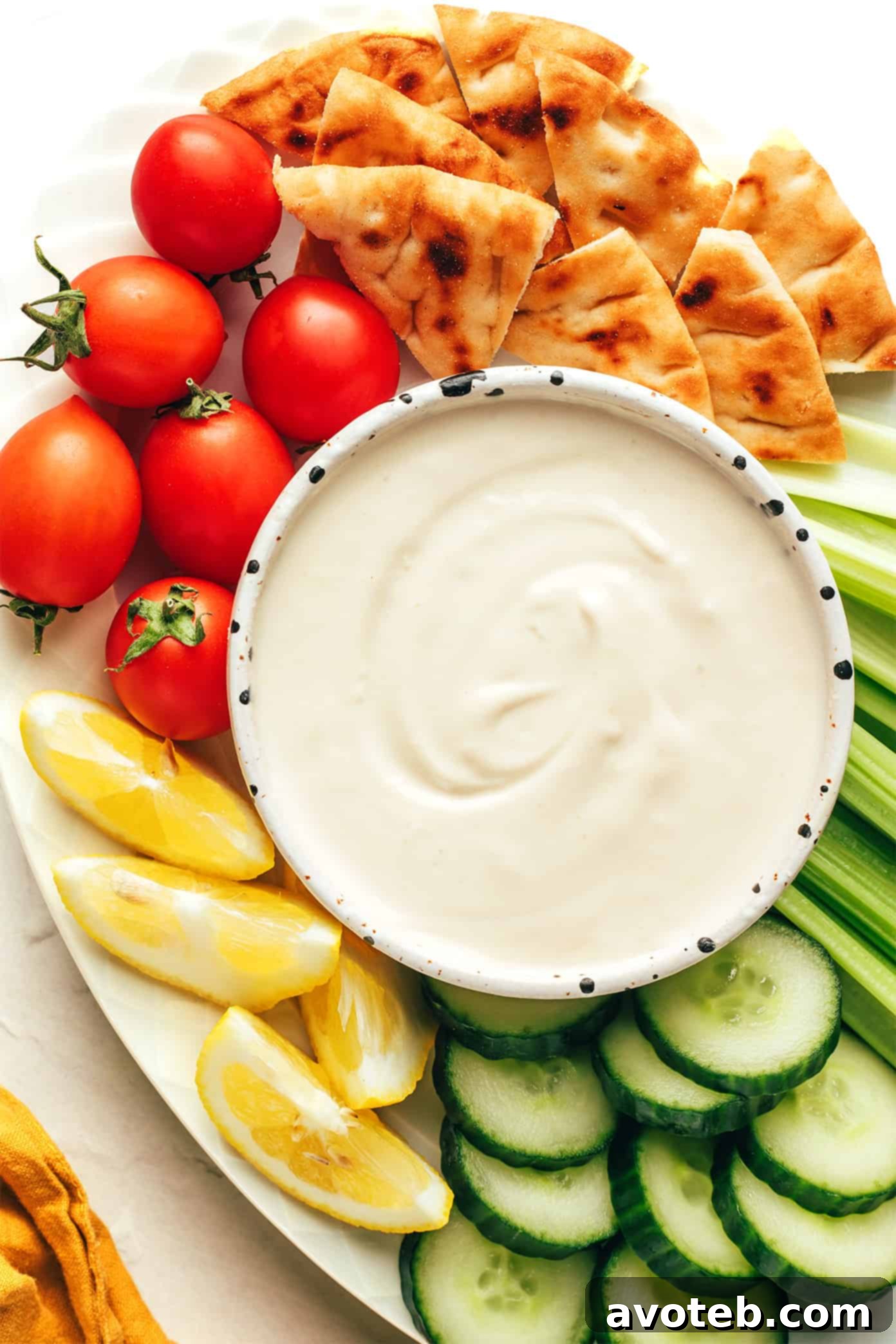 This homemade tahini sauce recipe is quick and easy to make with 5 ingredients and tastes amazing with everything from falafel to roasted veggies, grilled meats, wraps, salads and more. It's naturally gluten free and vegan, and easy to customize with extra herbs, spices or sweetener if you'd like. | gimmesomeoven.com Tahini sauce served in a small bowl with fresh cut vegetables and pita bread for dipping