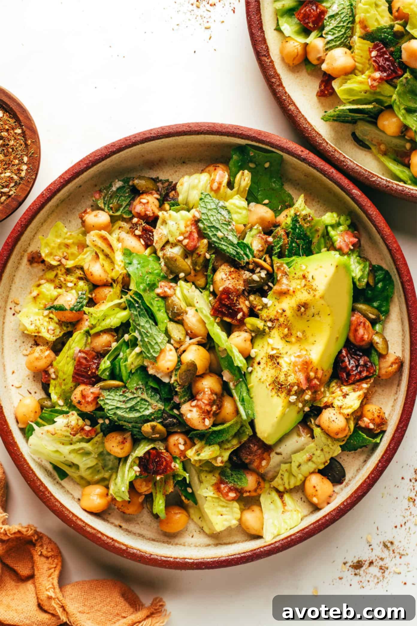 This vibrant green salad is loaded up with chickpeas, Medjool dates, avocado, pepitas, loads of fresh mint, and tossed with a lemony za'atar shallot vinaigrette. It's naturally vegan and gluten-free, but feel free to add a protein such as chicken, steak, shrimp or salmon if you'd like. So fresh and delicious! | gimmesomeoven.com Vibrant Chickpea, Date, and Avocado Salad with Za'atar Vinaigrette in serving bowls