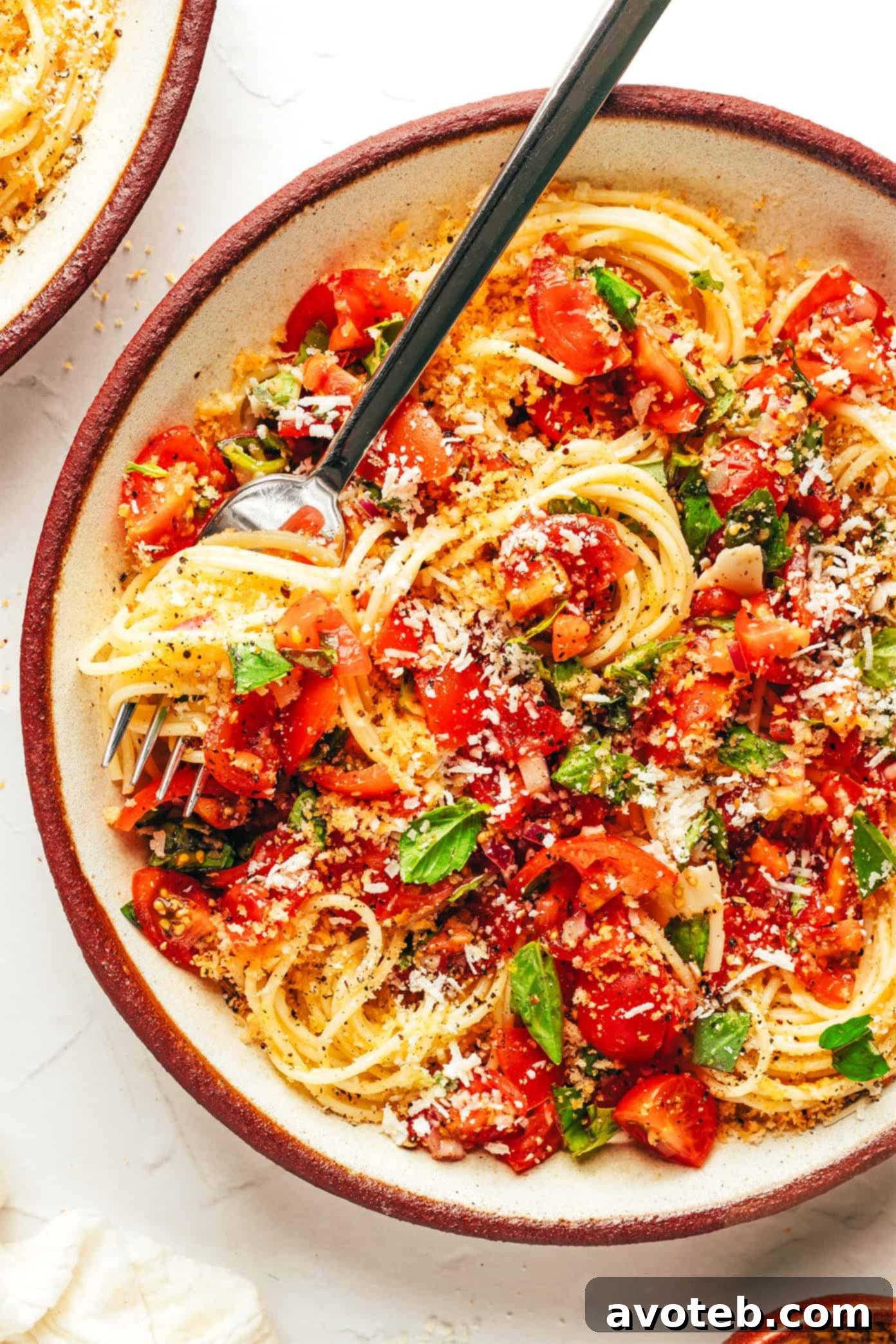 A large serving of Bruschetta Pasta garnished with extra basil and Parmesan cheese.