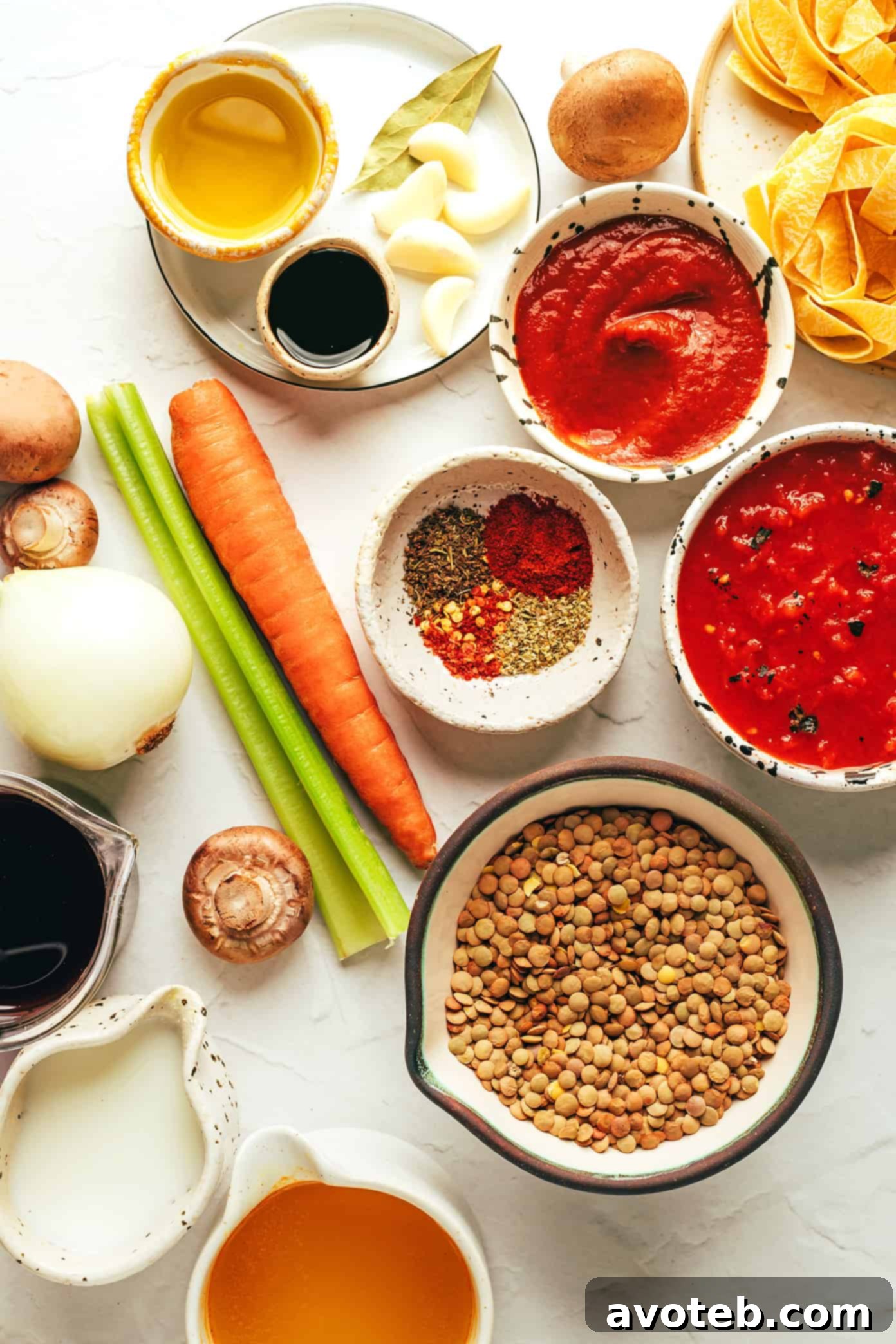Ingredients laid out for a hearty, gluten-free, vegetarian, and vegan lentil bolognese, featuring a rich, garlicky mushroom-herb tomato sauce base, ready to be served with various dishes. Ingredients for Vegetarian Bolognese including lentils, vegetables, and tomatoes