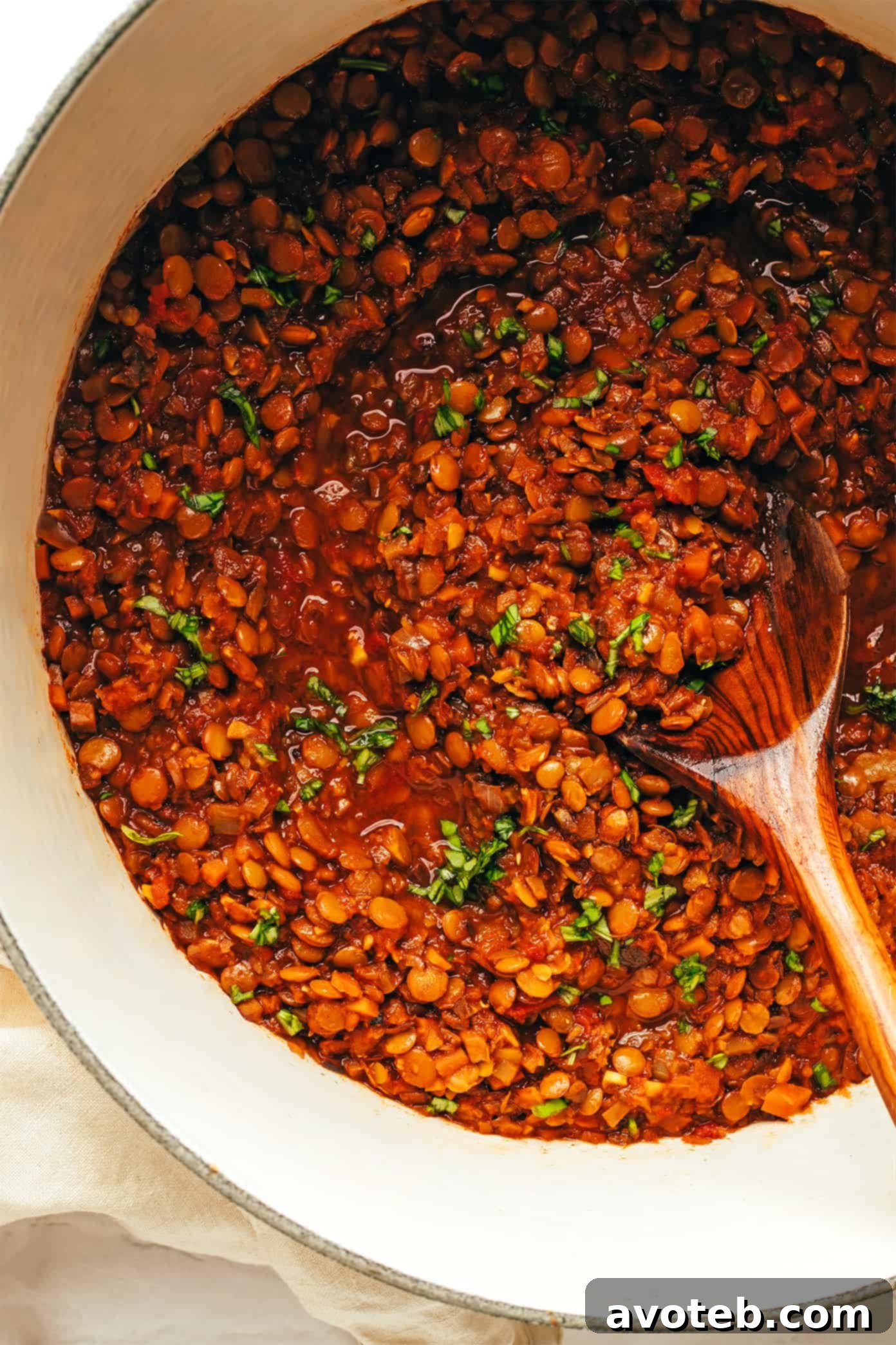 A close-up view of the simmering, hearty lentil bolognese sauce in a pot, highlighting its rich texture and deep color from the garlicky mushroom-herb tomato blend. Close-up of Vegetarian Bolognese Sauce simmering in a pot