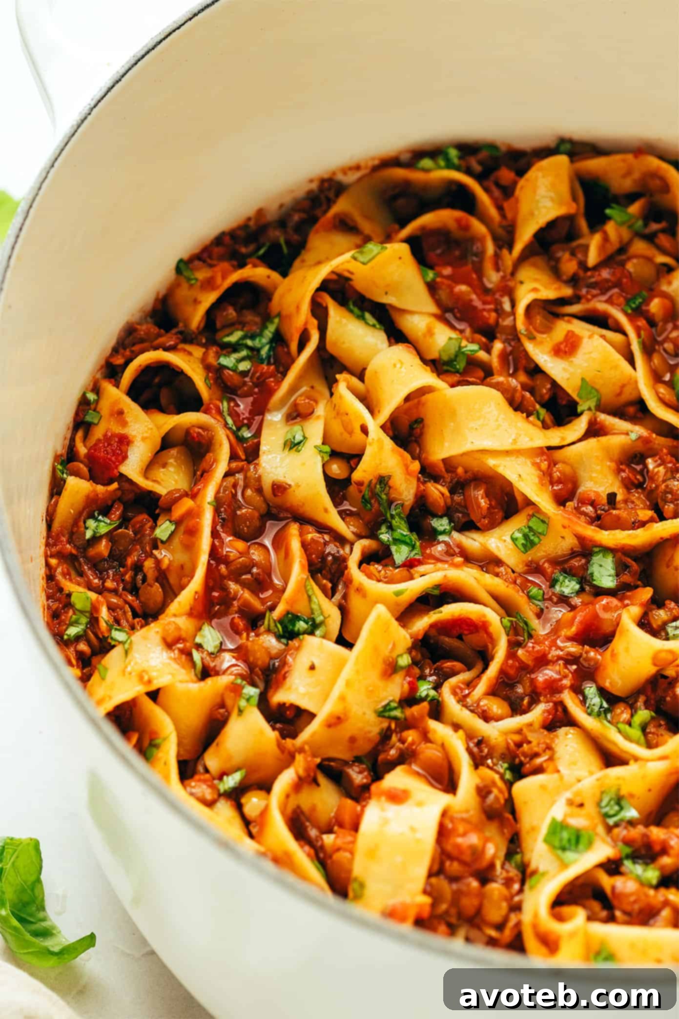 A large pot of hearty lentil pasta alla bolognese, simmering to perfection, illustrating the deep, rich colors of the vegetarian and vegan sauce. Lentil pasta alla bolognese simmering in a pot