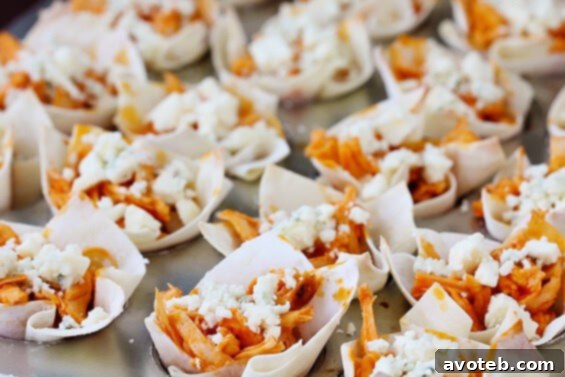 Close-up of baked Buffalo Chicken Wonton Cups with blue cheese and scallions