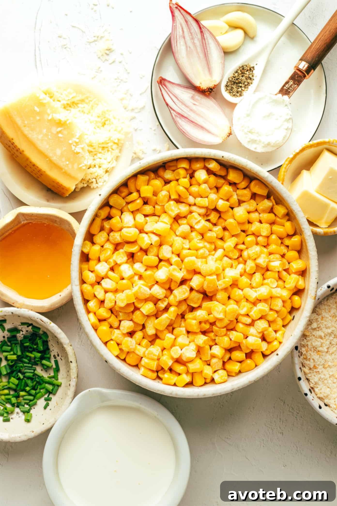 Ingredients for Parmesan Creamed Corn including fresh corn, Parmesan cheese, shallots, garlic, half and half, honey, and smoked paprika.