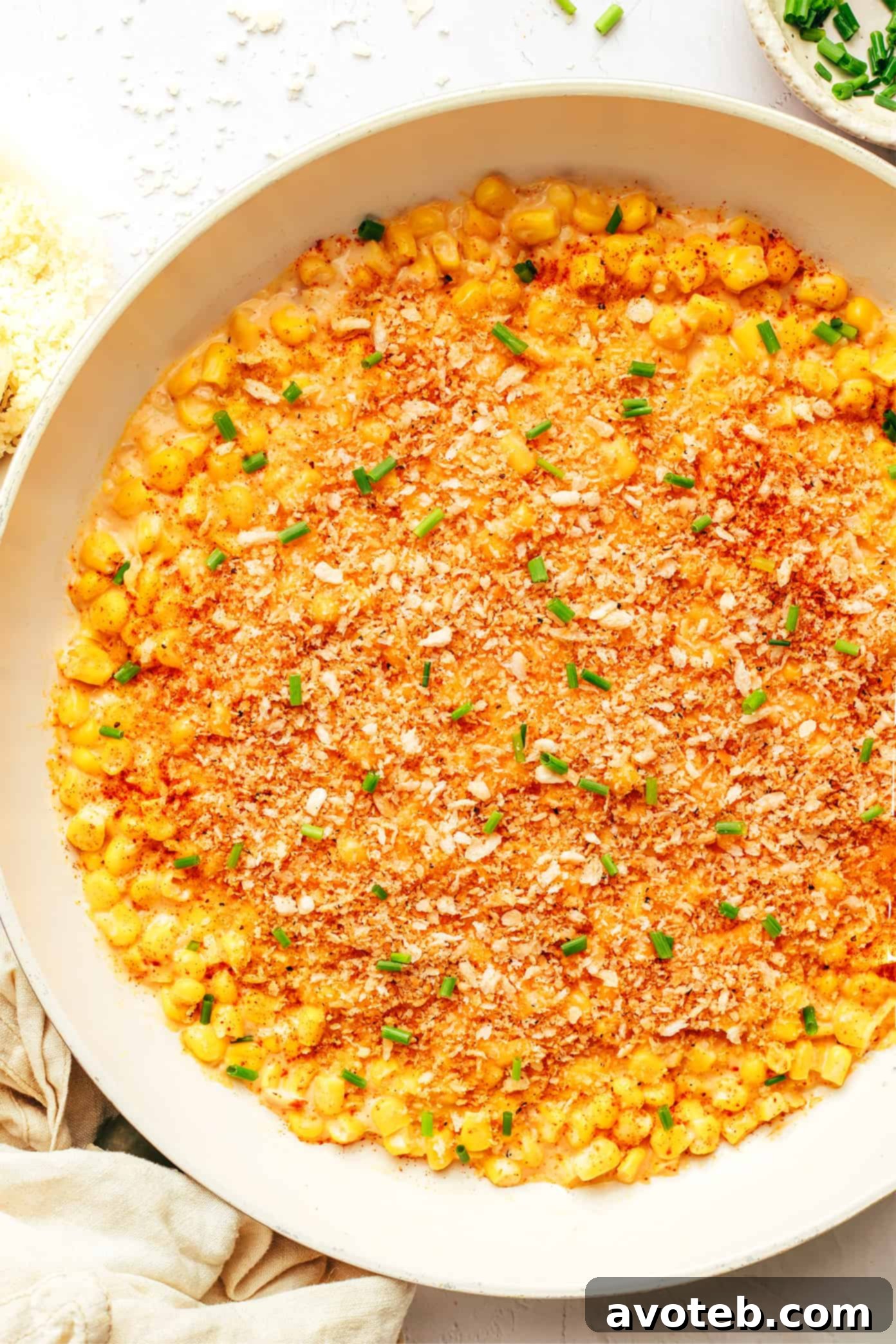 Parmesan Creamed Corn served in a skillet, topped generously with crispy garlicky breadcrumbs.