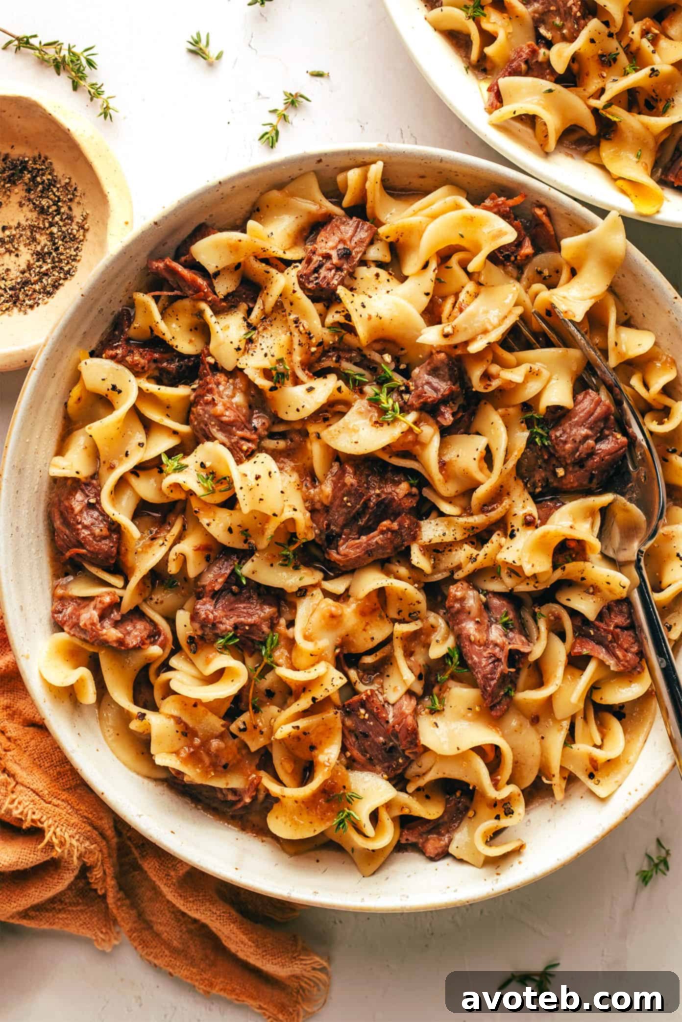 A serving of Grandma's beef and noodles in a white bowl, ready to be enjoyed.