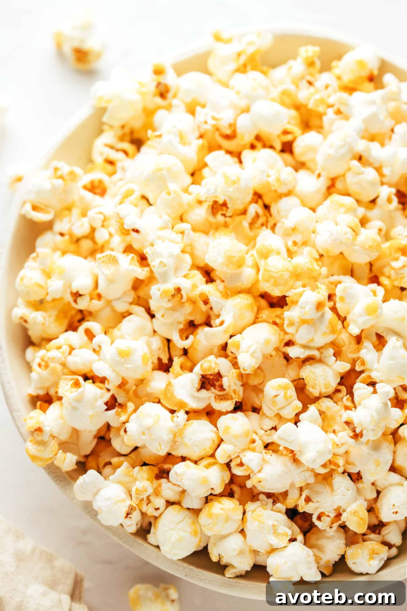A hand gently shaking a covered pot on the stovetop, popping kettle corn.