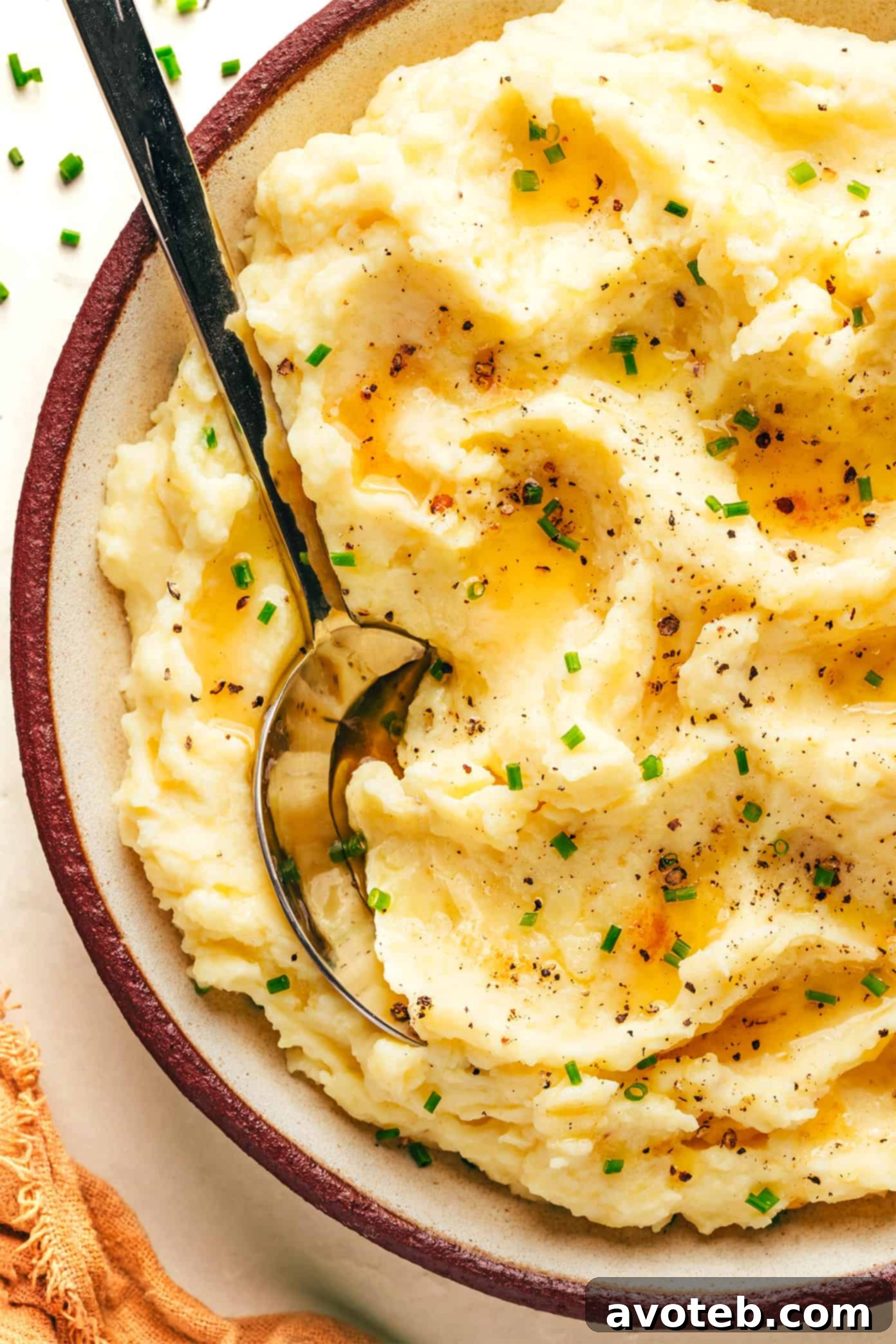Golden Nutty Potato Mash 8 A full bowl of brown butter mashed potatoes with a serving spoon, ready for a festive meal.