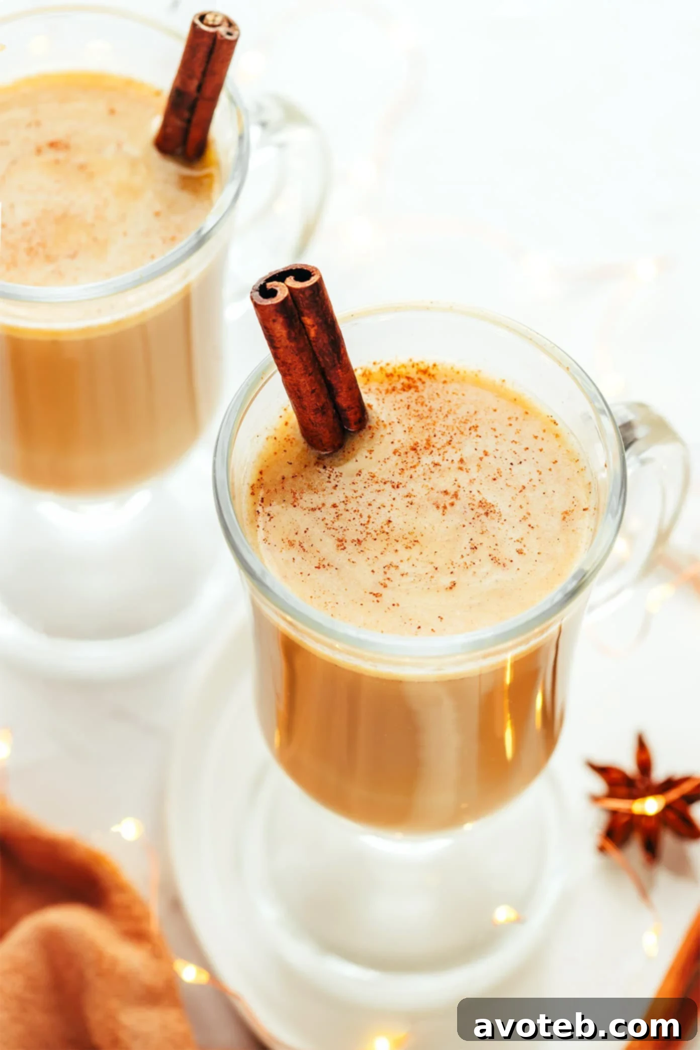 A warm mug of hot buttered rum garnished with a cinnamon stick, steam rising from its creamy surface.