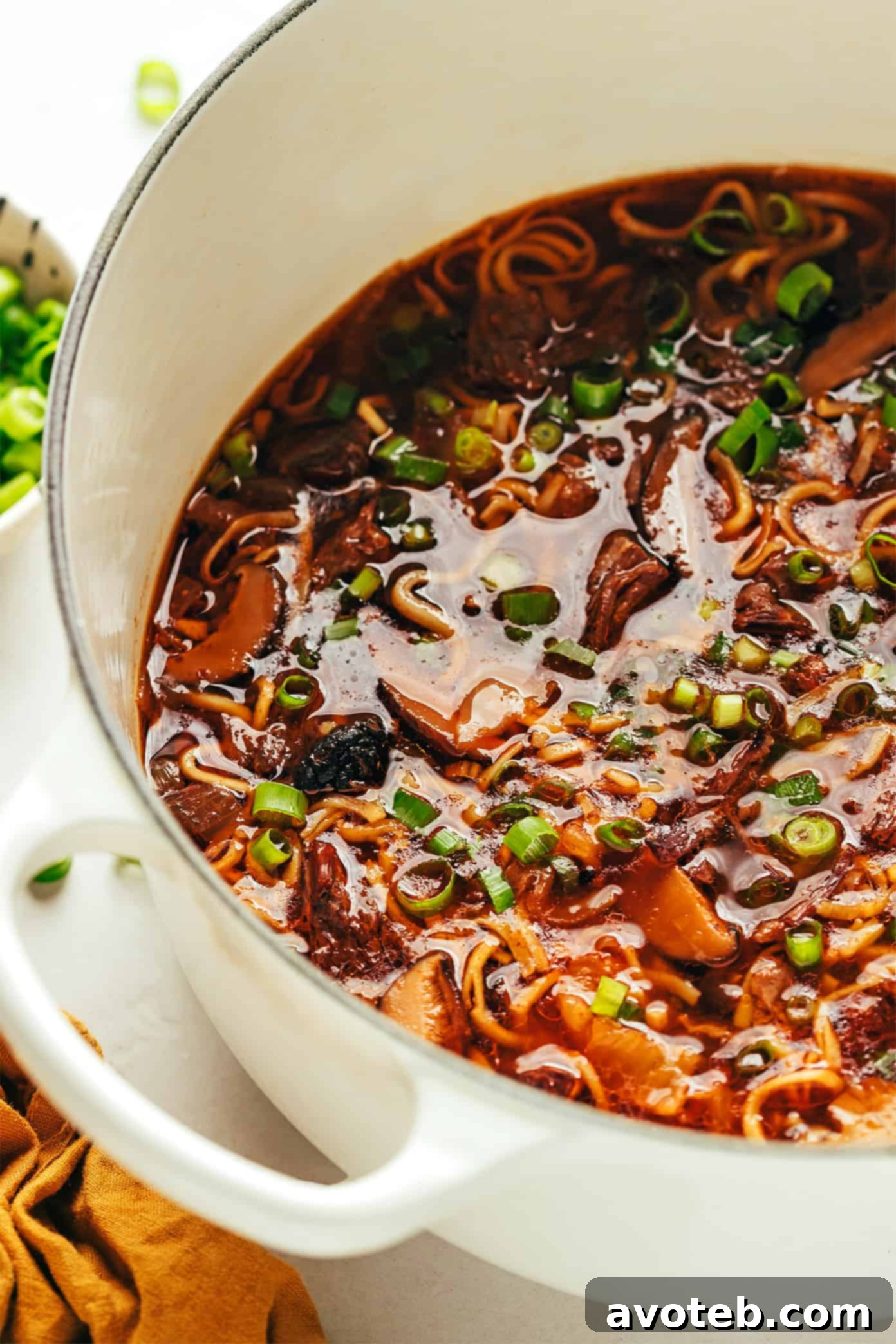 A steaming bowl of Kimchi Beef Noodle Soup with tender beef, noodles, and green onions