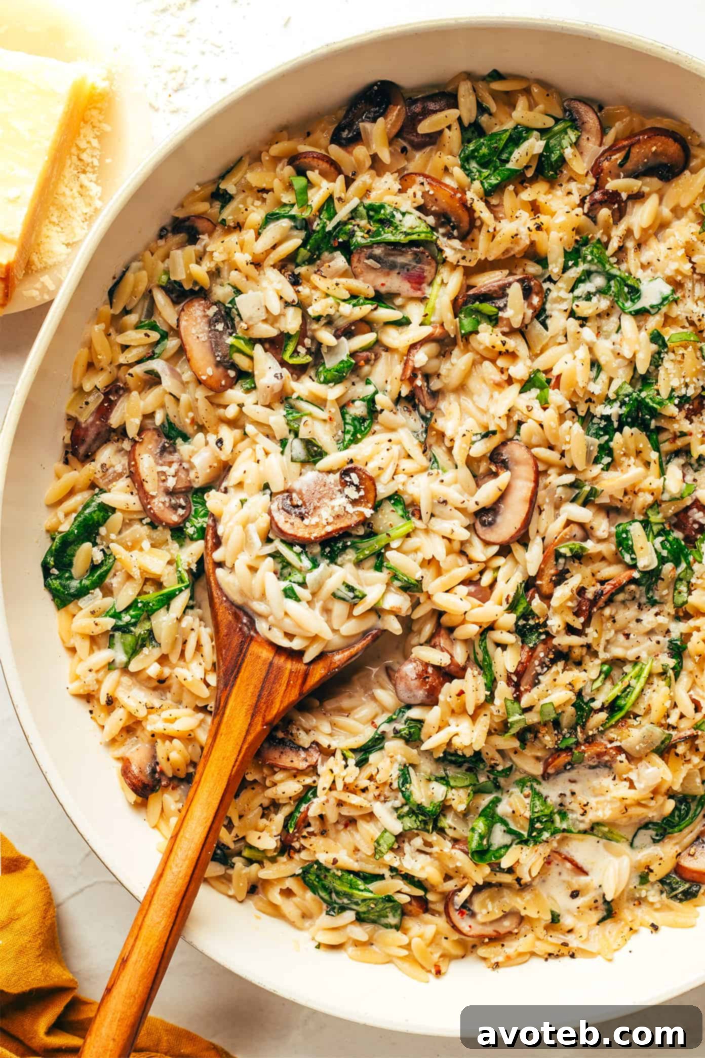 Creamy Garlic Mushroom Orzo Pasta served in a bowl, garnished with fresh basil and Parmesan cheese.