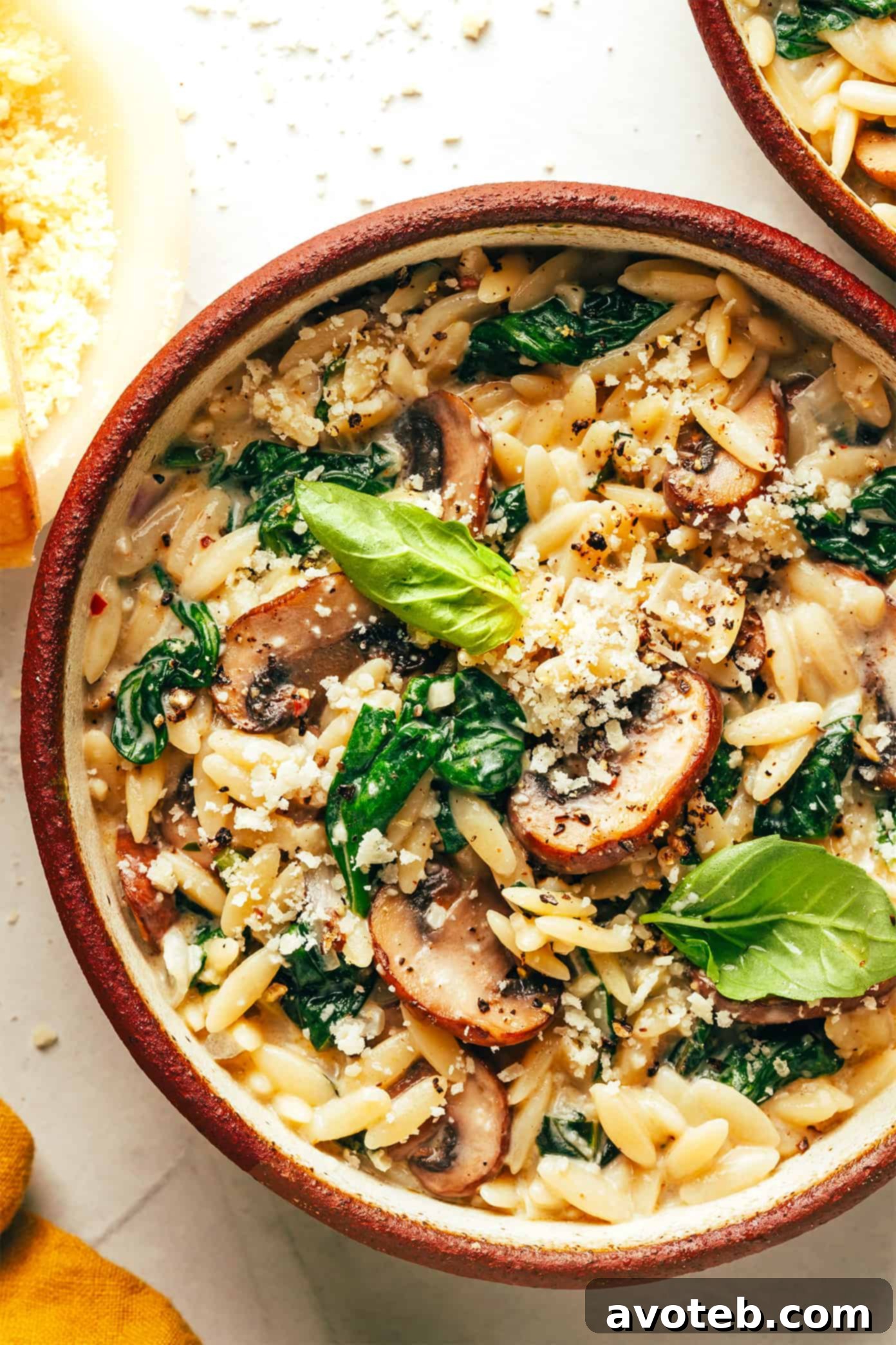 A final overhead shot of the creamy garlic mushroom orzo pasta, showing the vibrant green spinach and golden mushrooms.