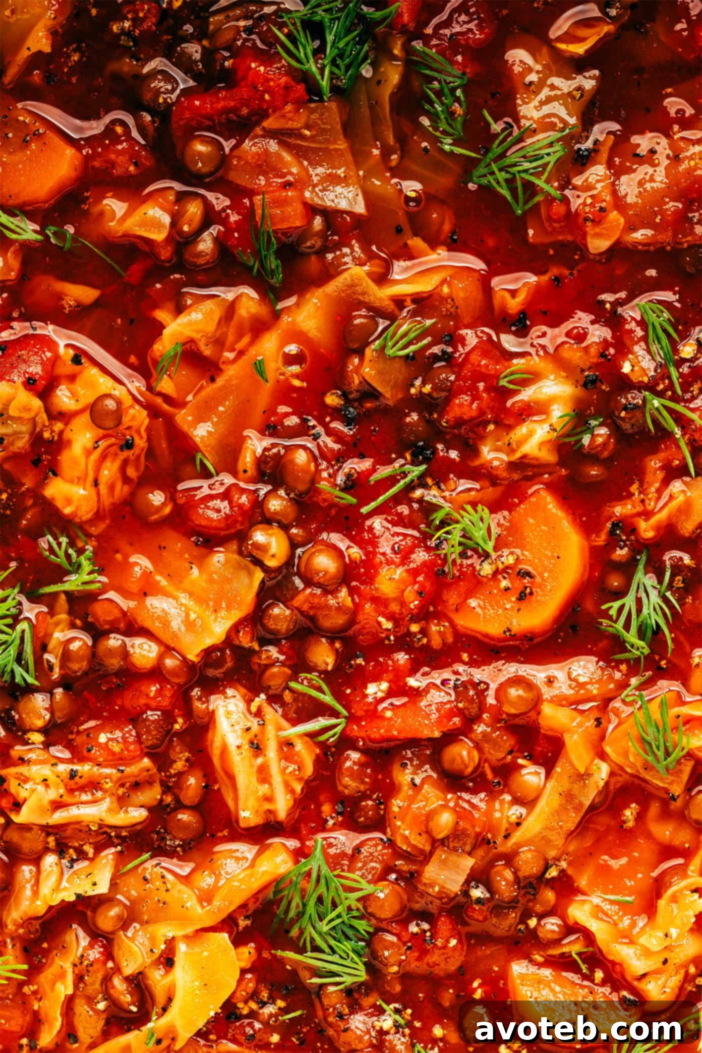 A side shot of a single bowl of Vegetarian Cabbage Roll Soup, focusing on its layers of ingredients and fresh garnishes.