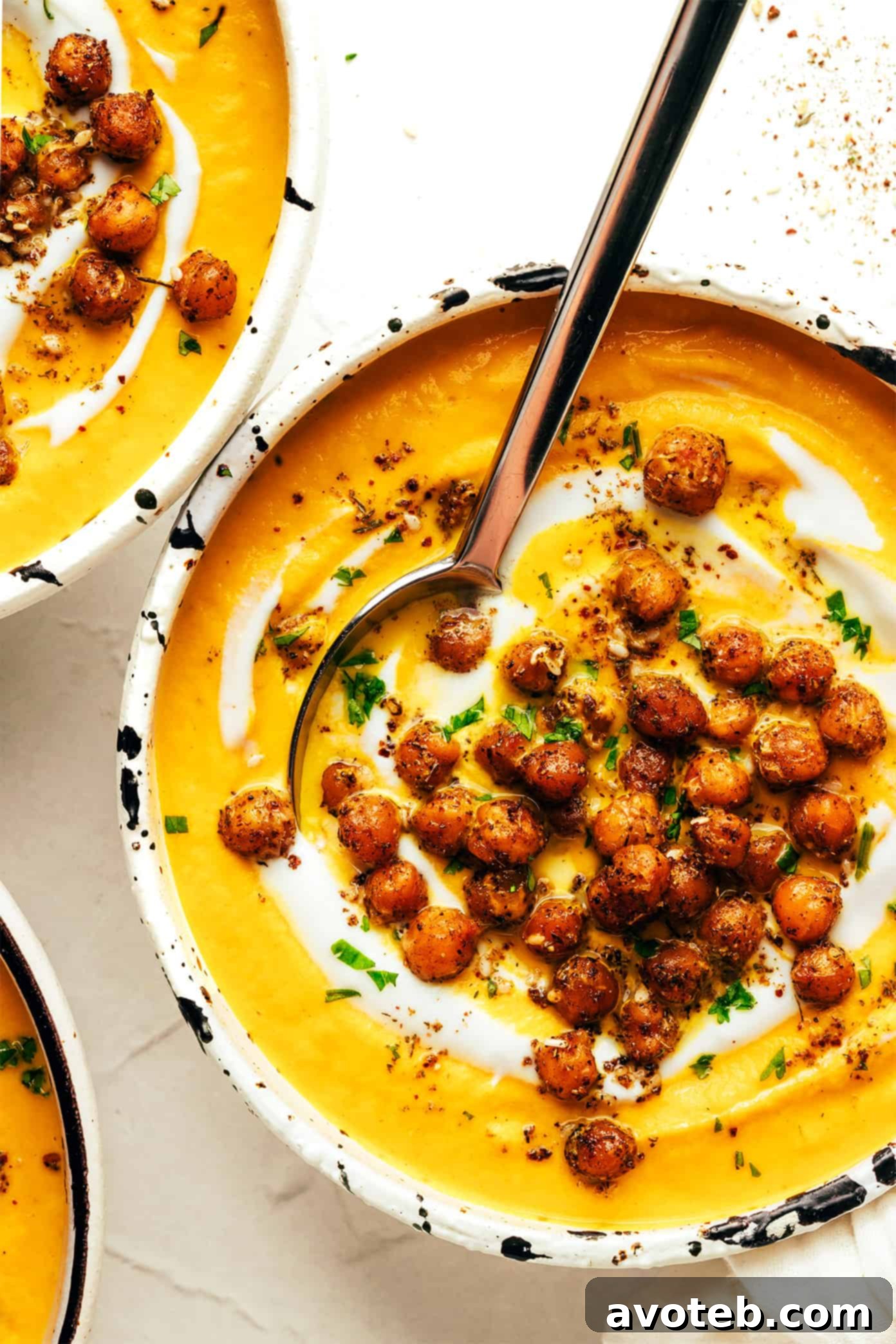 Roasted Carrot Soup with Za'atar Chickpeas in a bowl, garnished with cilantro and chickpeas.