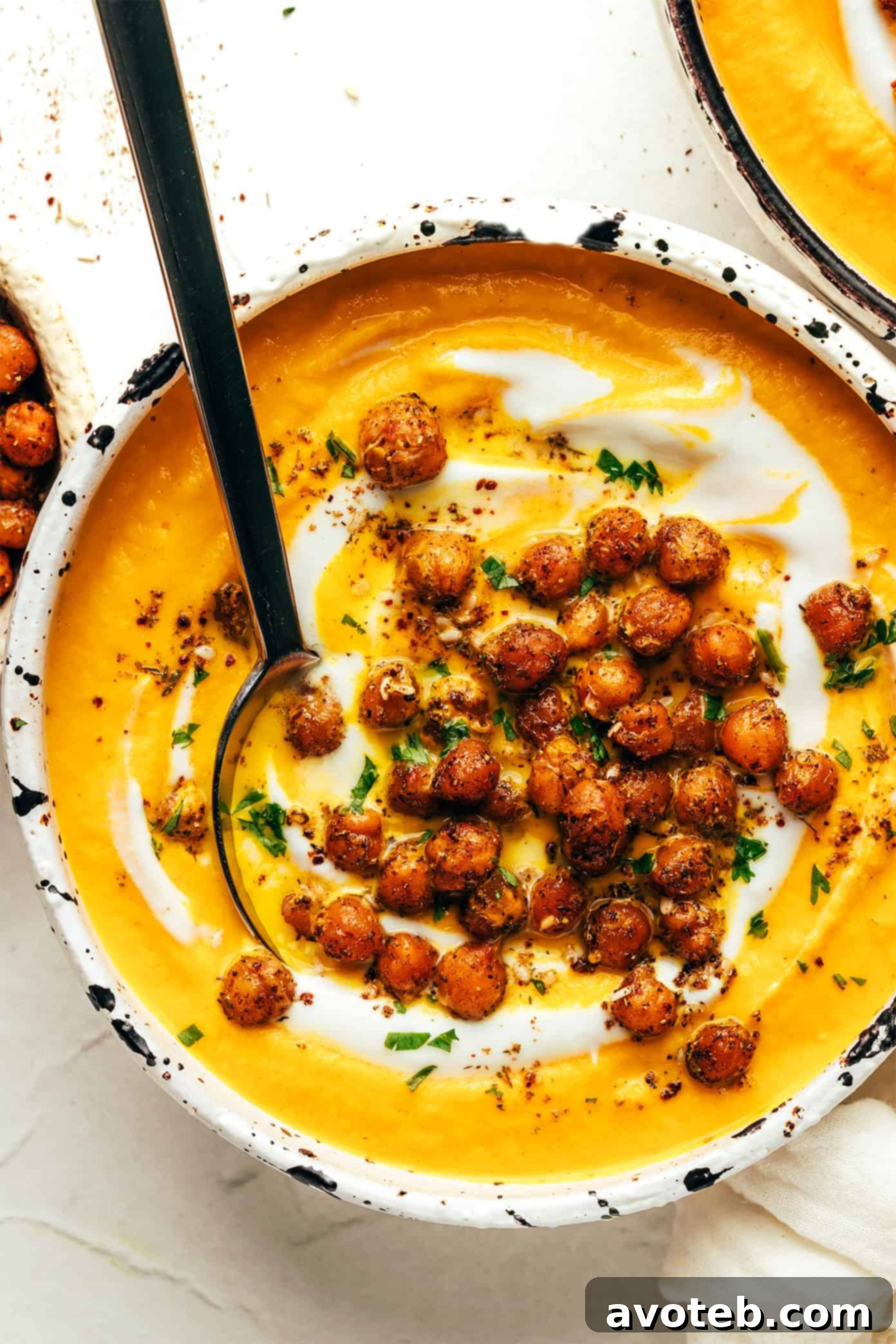 A bowl of roasted carrot soup with fresh cilantro garnish.