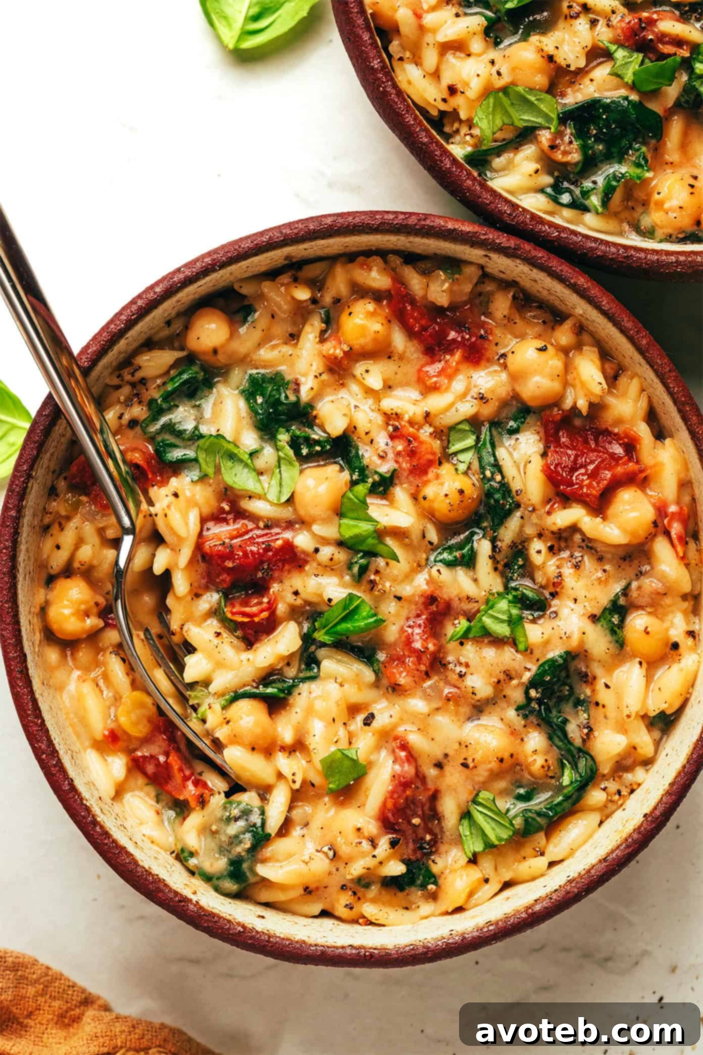 A perfectly plated Marry Me Chickpeas and Orzo dish, garnished with fresh basil, showcasing its creamy texture and vibrant ingredients.